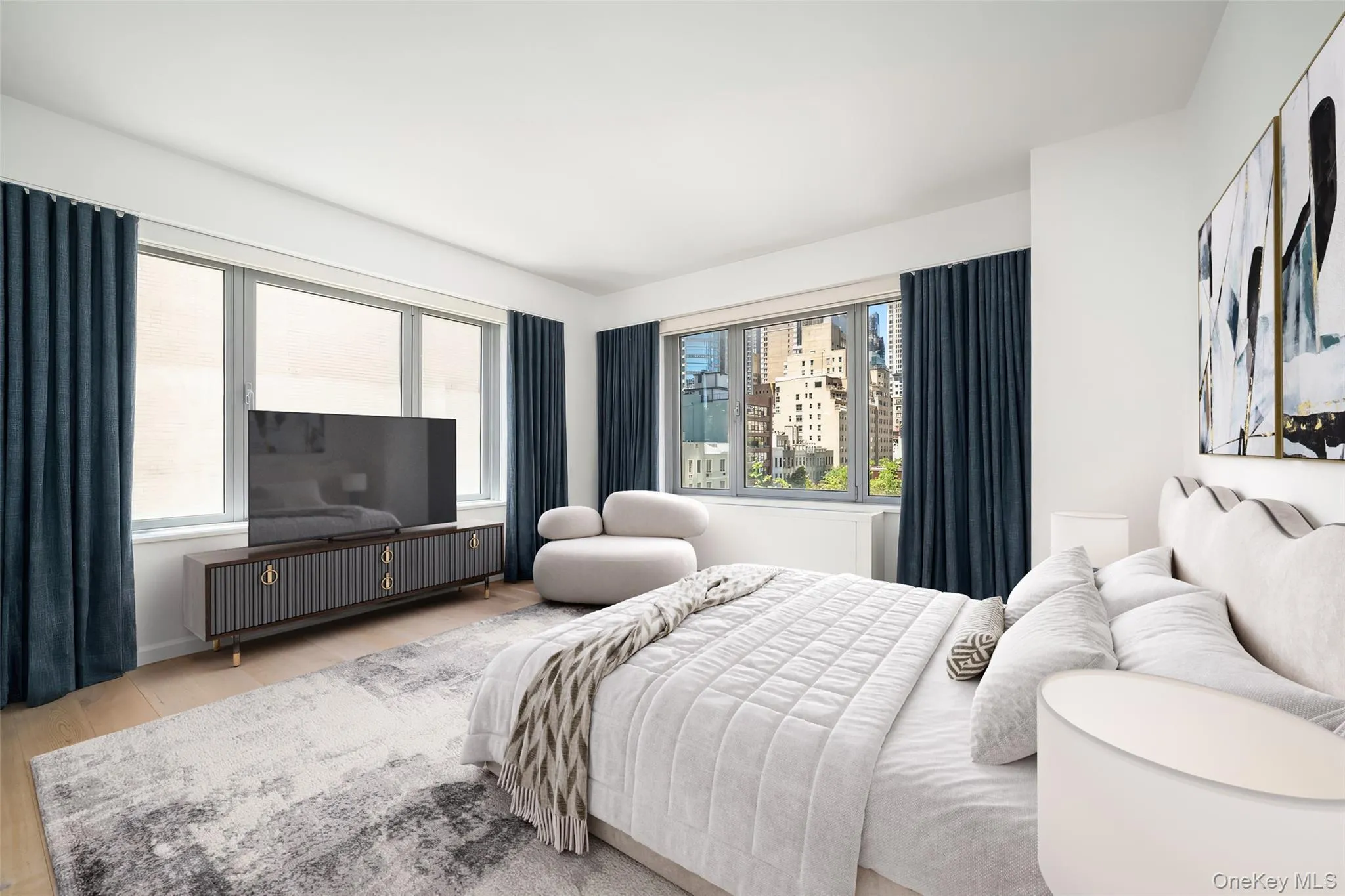 Bright room featuring light wood-finish flooring, a full wall of windows with dark drapery, and a contemporary media console Bright room featuring light wood-finish flooring, a full wall of windows with dark drapery, and a contemporary media console