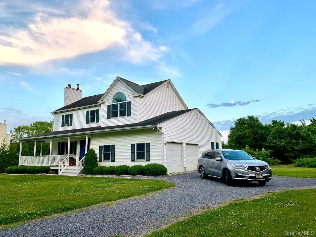 Front of House with covered front porch, attached two-car garage, and a gravel driveway Front of House with covered front porch, attached two-car garage, and a gravel driveway
