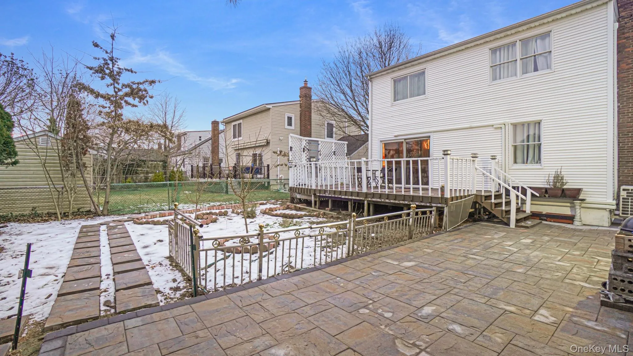 Snow covered house featuring a patio, fence, and a deck Snow covered house featuring a patio, fence, and a deck