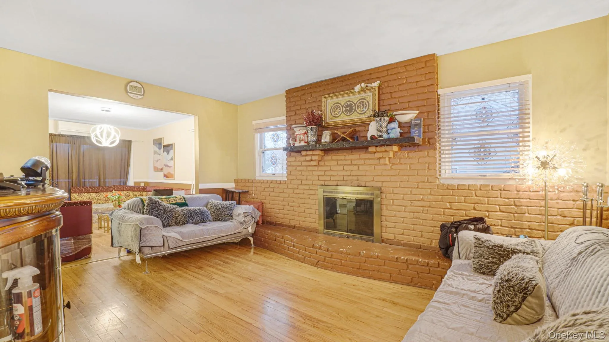 Living room with hardwood / wood-style flooring and a brick fireplace Living room with hardwood / wood-style flooring and a brick fireplace