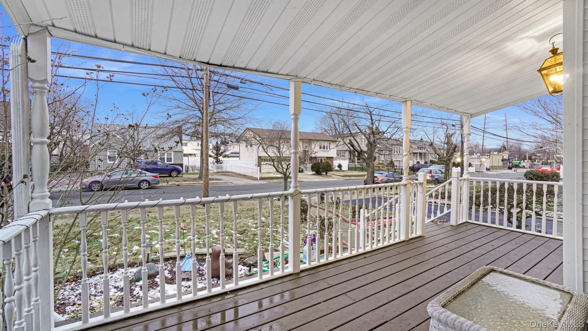 Wooden terrace featuring covered porch and a residential view Wooden terrace featuring covered porch and a residential view