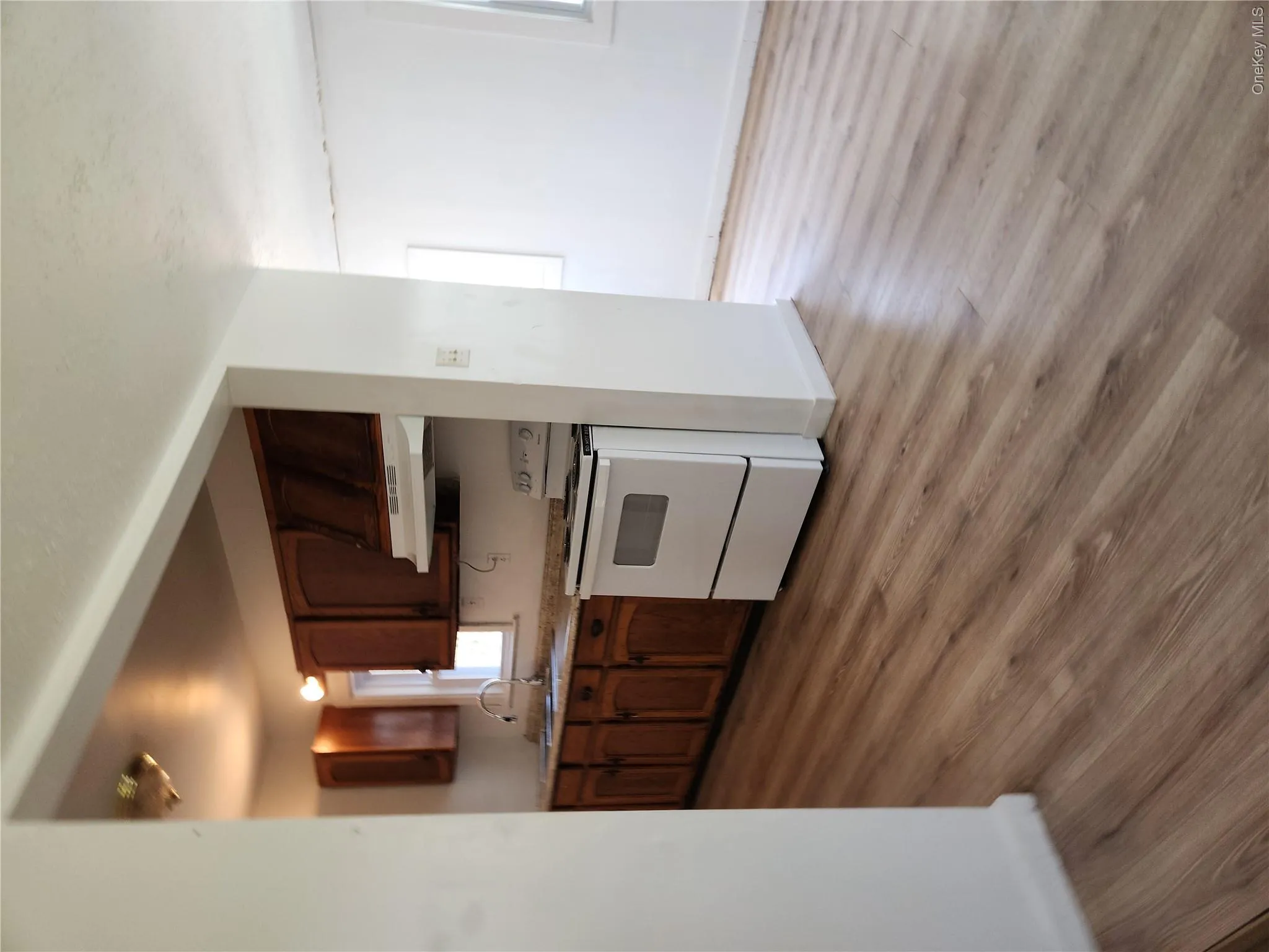 Kitchen with light laminate wood-style floors, white new electric stove, exhaust hood Kitchen with light laminate wood-style floors, white new electric stove, exhaust hood