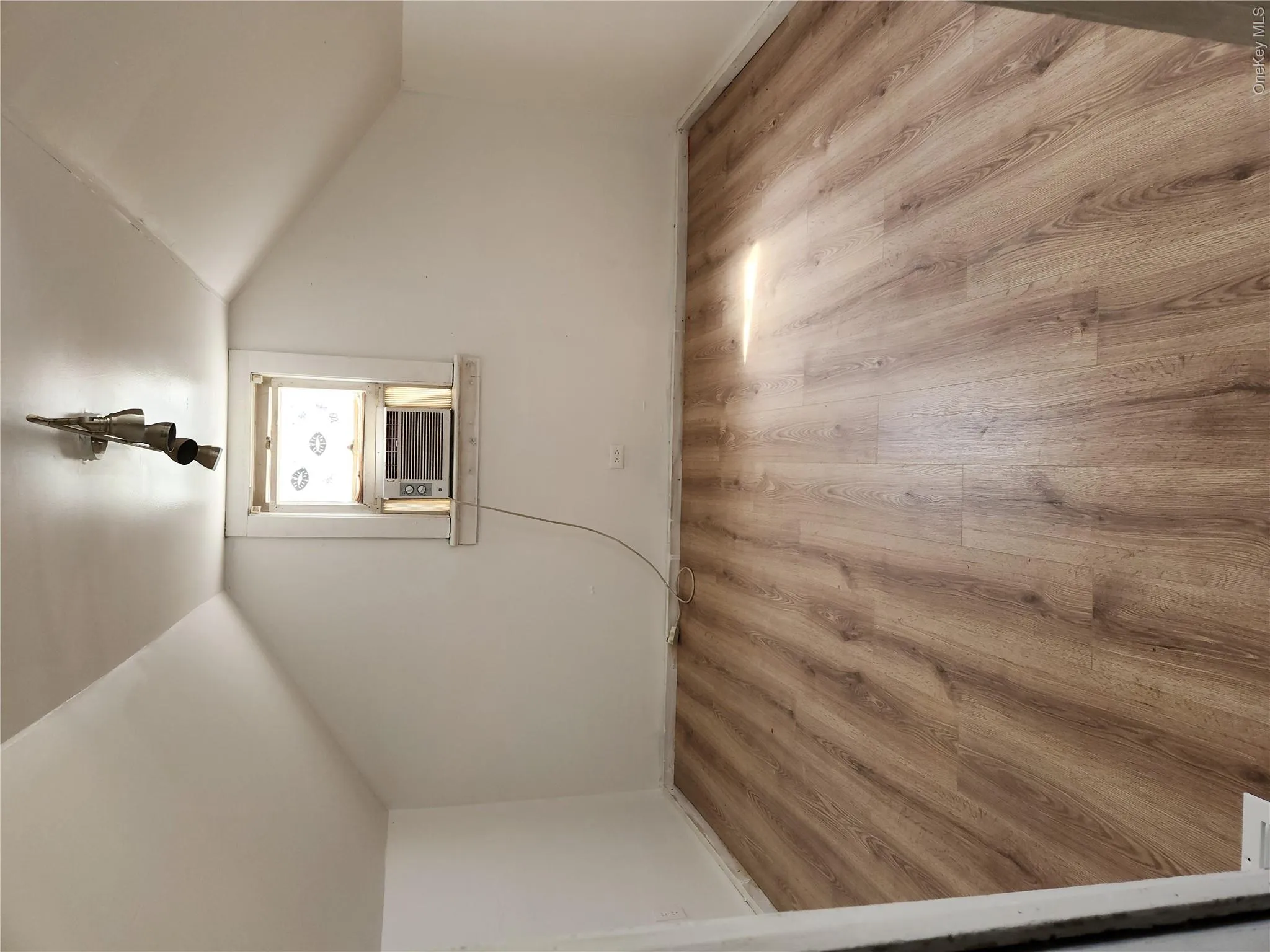 Additional living space with light laminate wood finished floors, and vaulted ceiling Additional living space with light laminate wood finished floors, and vaulted ceiling