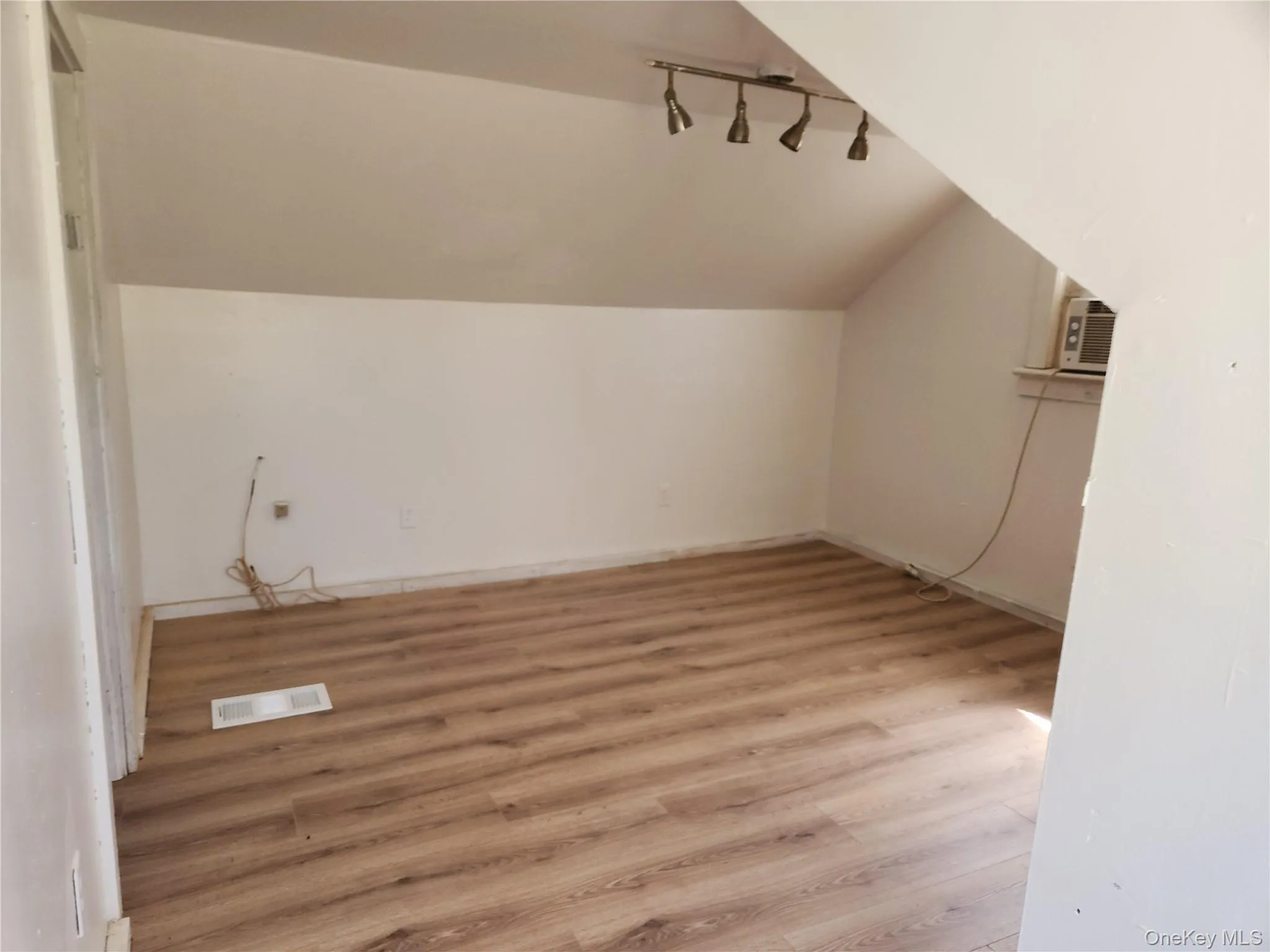 primary bedroom , left side, featuring visible vents, light laminate wood finished floors, and vaulted ceiling primary bedroom , left side, featuring visible vents, light laminate wood finished floors, and vaulted ceiling