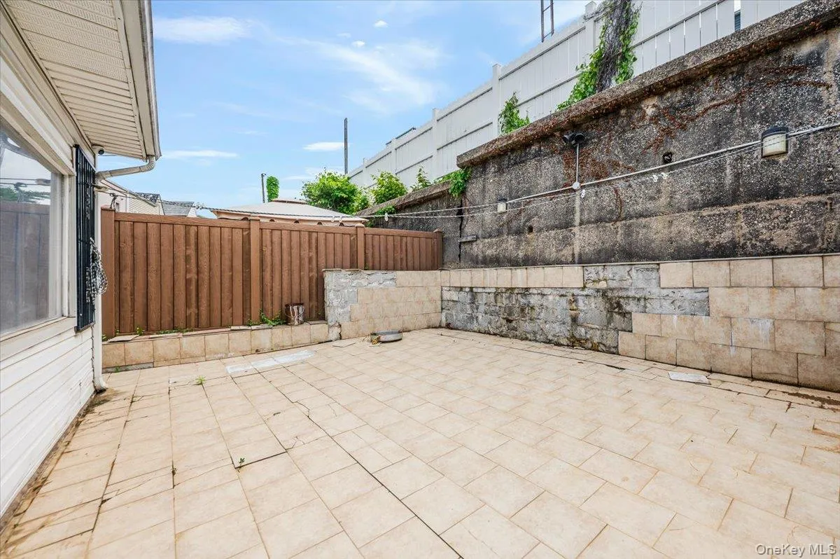 Expansive paved patio area featuring light-toned rectangular pavers Expansive paved patio area featuring light-toned rectangular pavers