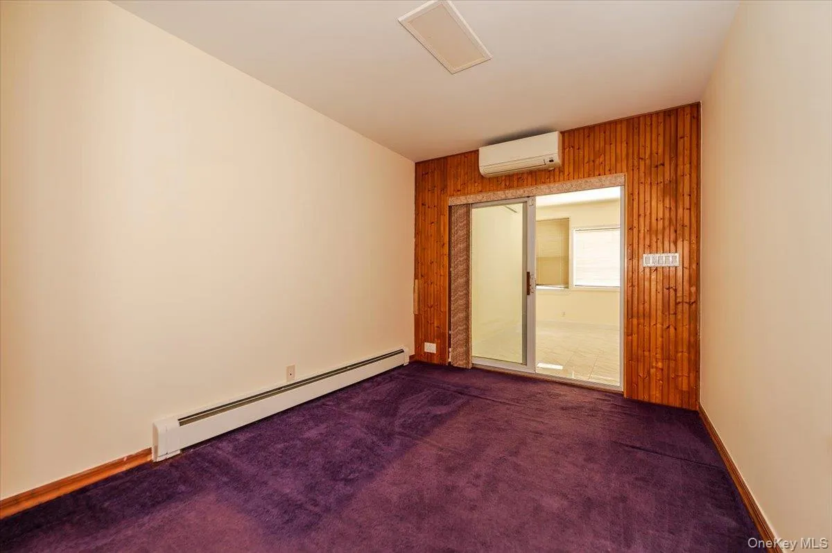 Interior room featuring deep purple carpeting and light beige walls Interior room featuring deep purple carpeting and light beige walls