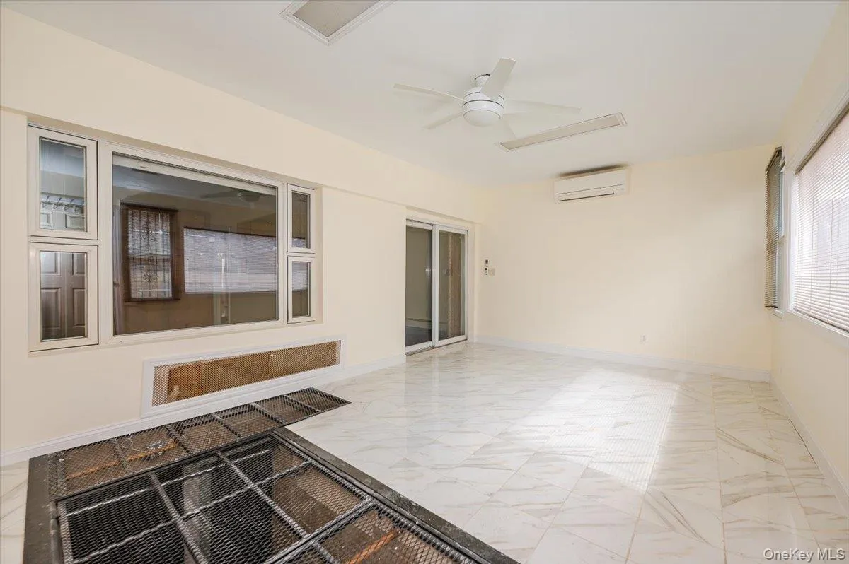 Spacious interior featuring white tile flooring and a ceiling fan Spacious interior featuring white tile flooring and a ceiling fan