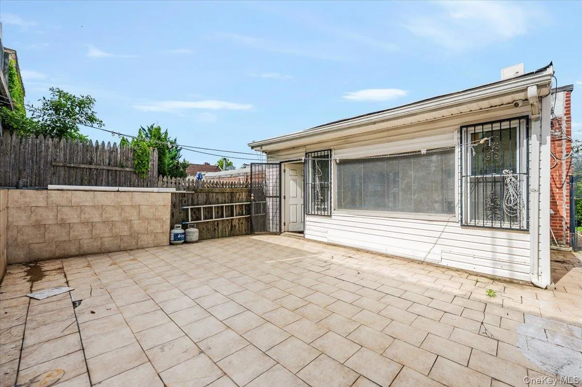 Paved outdoor space featuring rectangular pavers and a perimeter fence Paved outdoor space featuring rectangular pavers and a perimeter fence