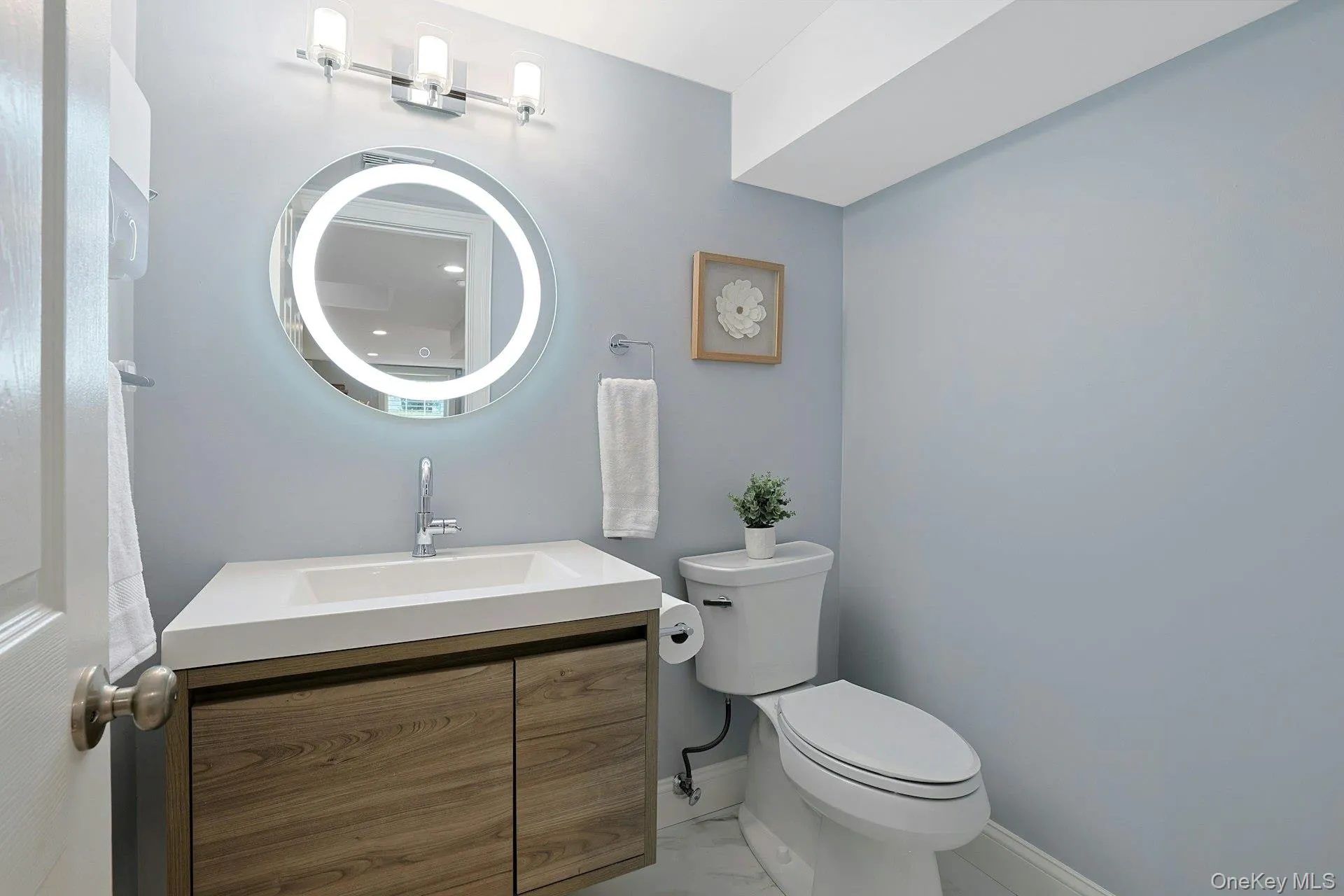 Convenient lower-level powder room with contemporary finishes. Convenient lower-level powder room with contemporary finishes.