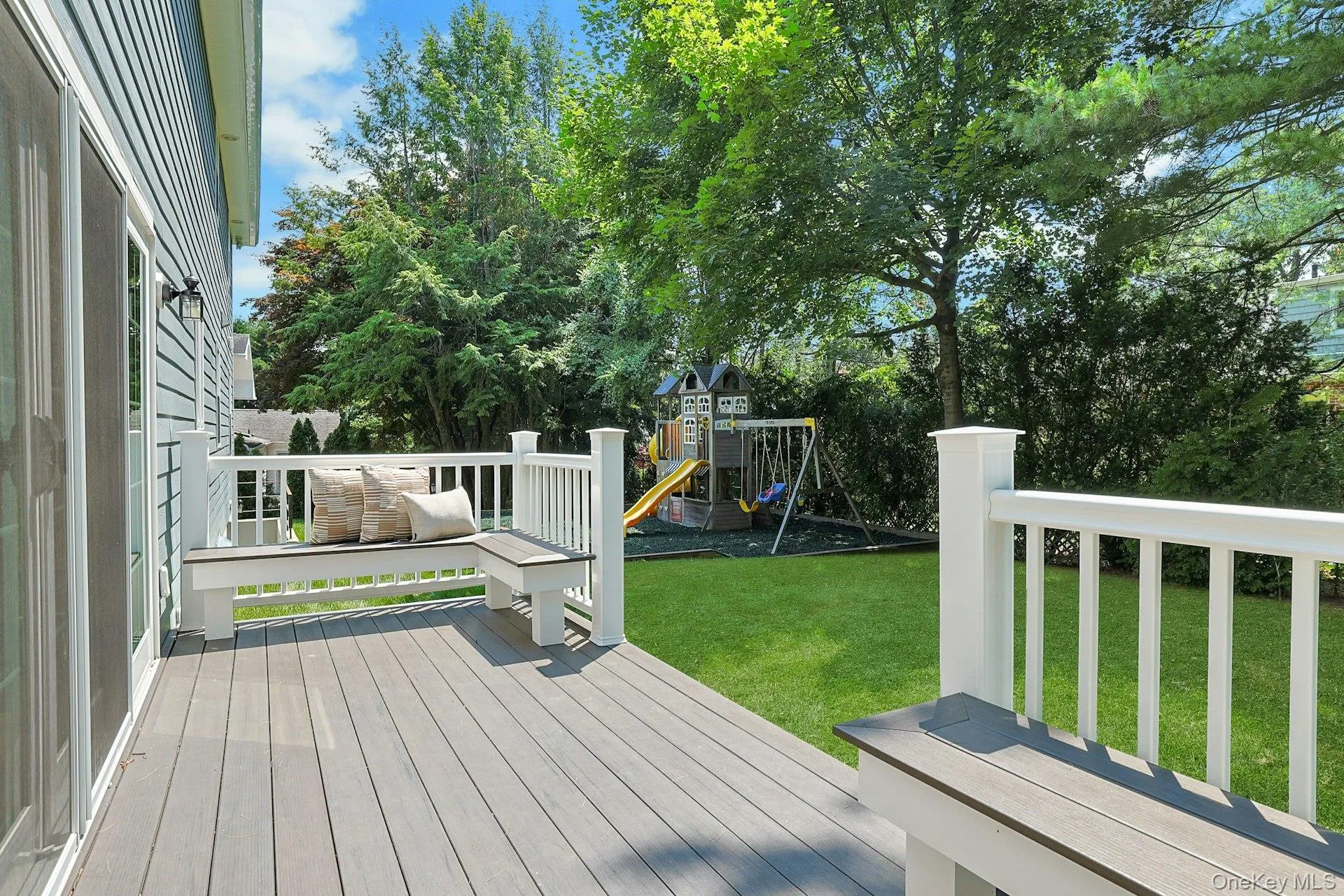 Deck with built-in benches overlooks the private, level backyard—perfect for outdoor dining and relaxing. Deck with built-in benches overlooks the private, level backyard—perfect for outdoor dining and relaxing.