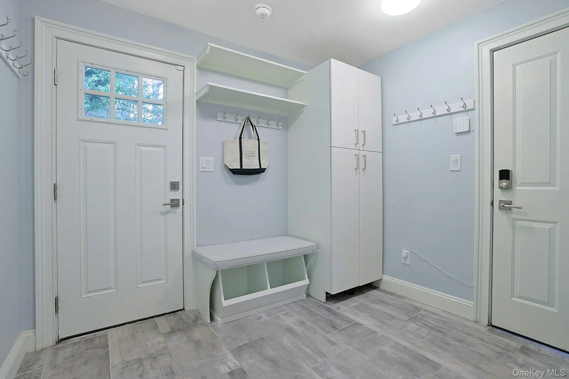 Practical mudroom with custom built-ins, laundry room, attached garage, and convenient side entrance. Practical mudroom with custom built-ins, laundry room, attached garage, and convenient side entrance.