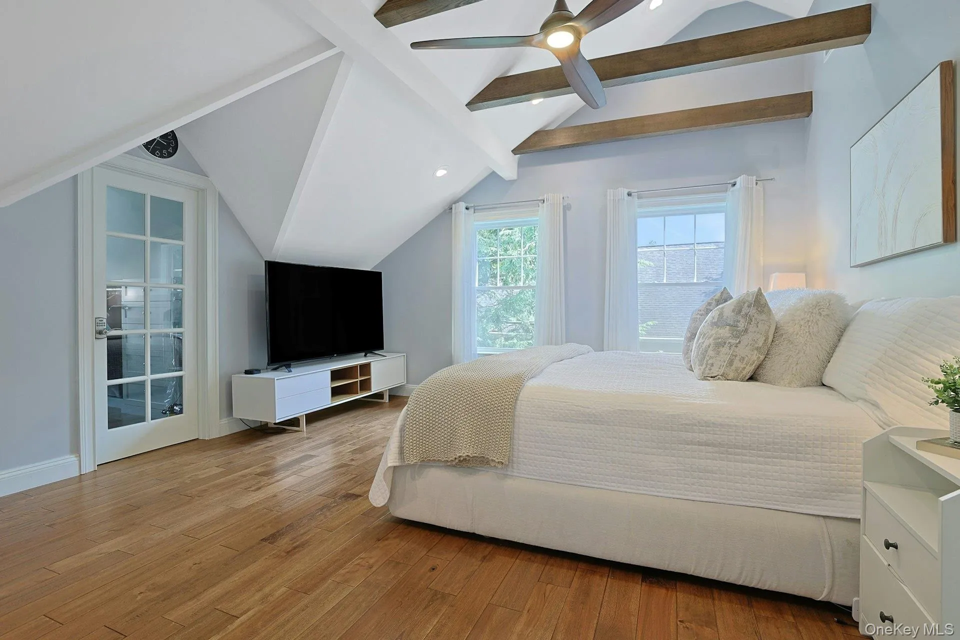 Luxurious primary suite with vaulted ceiling, architectural collar ties, and an expansive walk-in closet. Luxurious primary suite with vaulted ceiling, architectural collar ties, and an expansive walk-in closet.