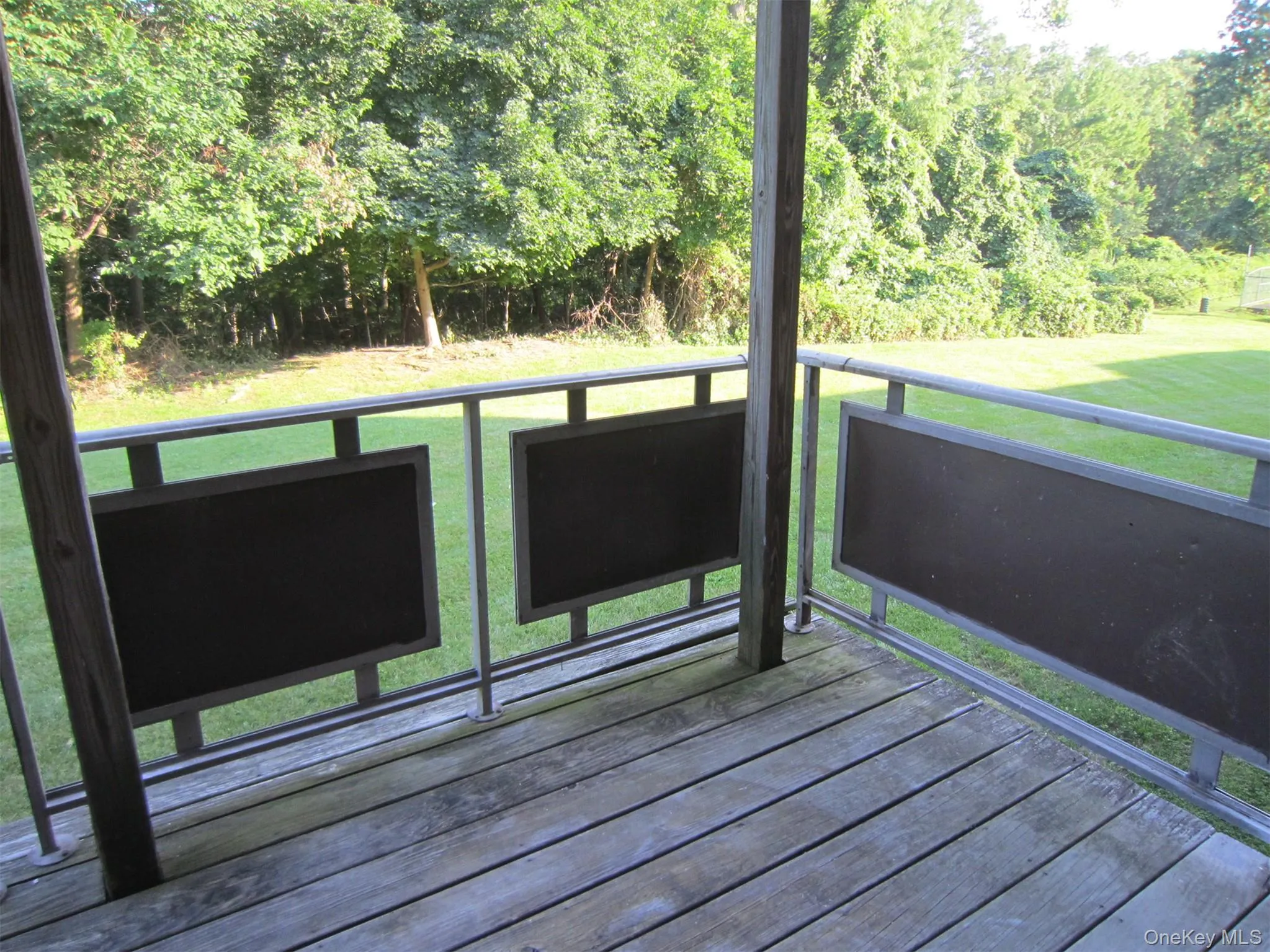 Private deck off the living room which overlooks a grassy area surrounded by trees Private deck off the living room which overlooks a grassy area surrounded by trees