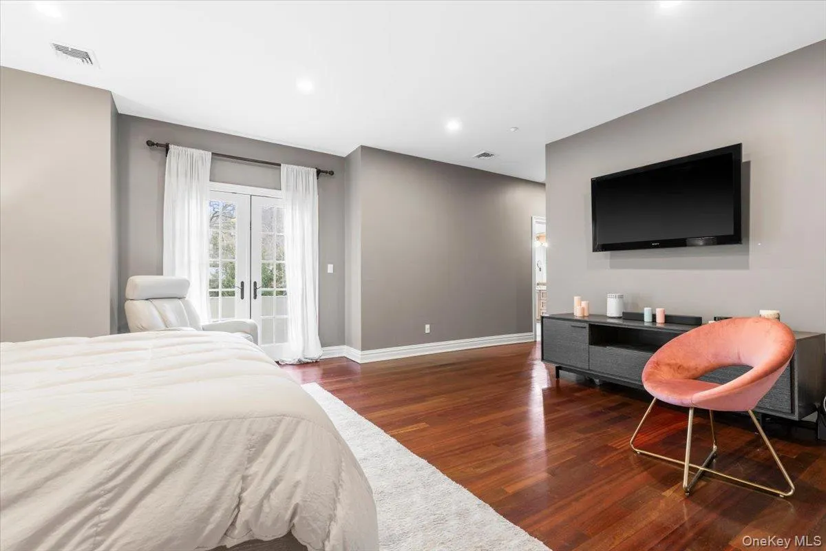 Expansive primary bedroom retreat featuring direct access to the outdoors and rich wood floors. Expansive primary bedroom retreat featuring direct access to the outdoors and rich wood floors.