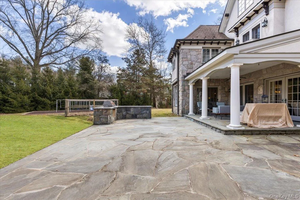 Covered outdoor veranda looking out over the stone patio and flat lawn area. Covered outdoor veranda looking out over the stone patio and flat lawn area.