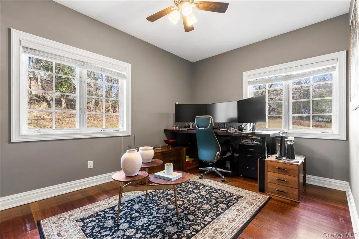 Quiet first-floor office or flexible bedroom featuring a cooling ceiling fan and handsome wood f Quiet first-floor office or flexible bedroom featuring a cooling ceiling fan and handsome wood f