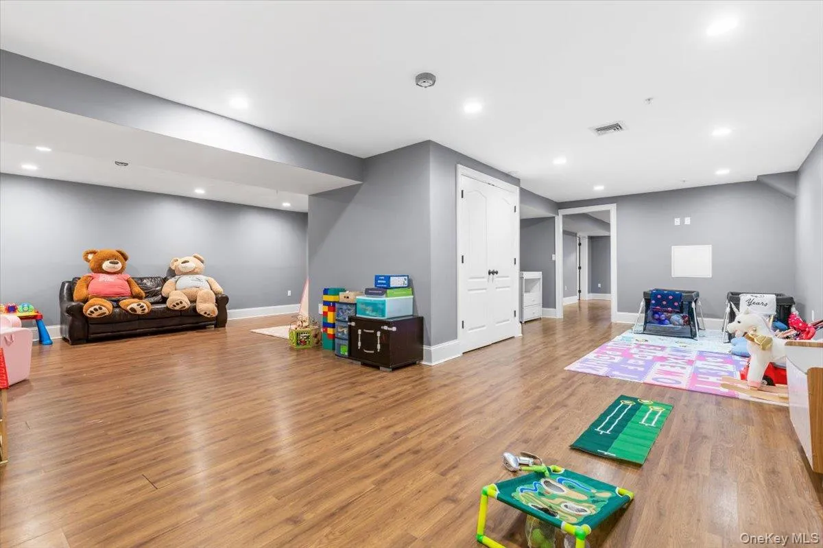 Expansive view of the multi-functional lower level highlighting light wood floors and recessed lighting Expansive view of the multi-functional lower level highlighting light wood floors and recessed lighting