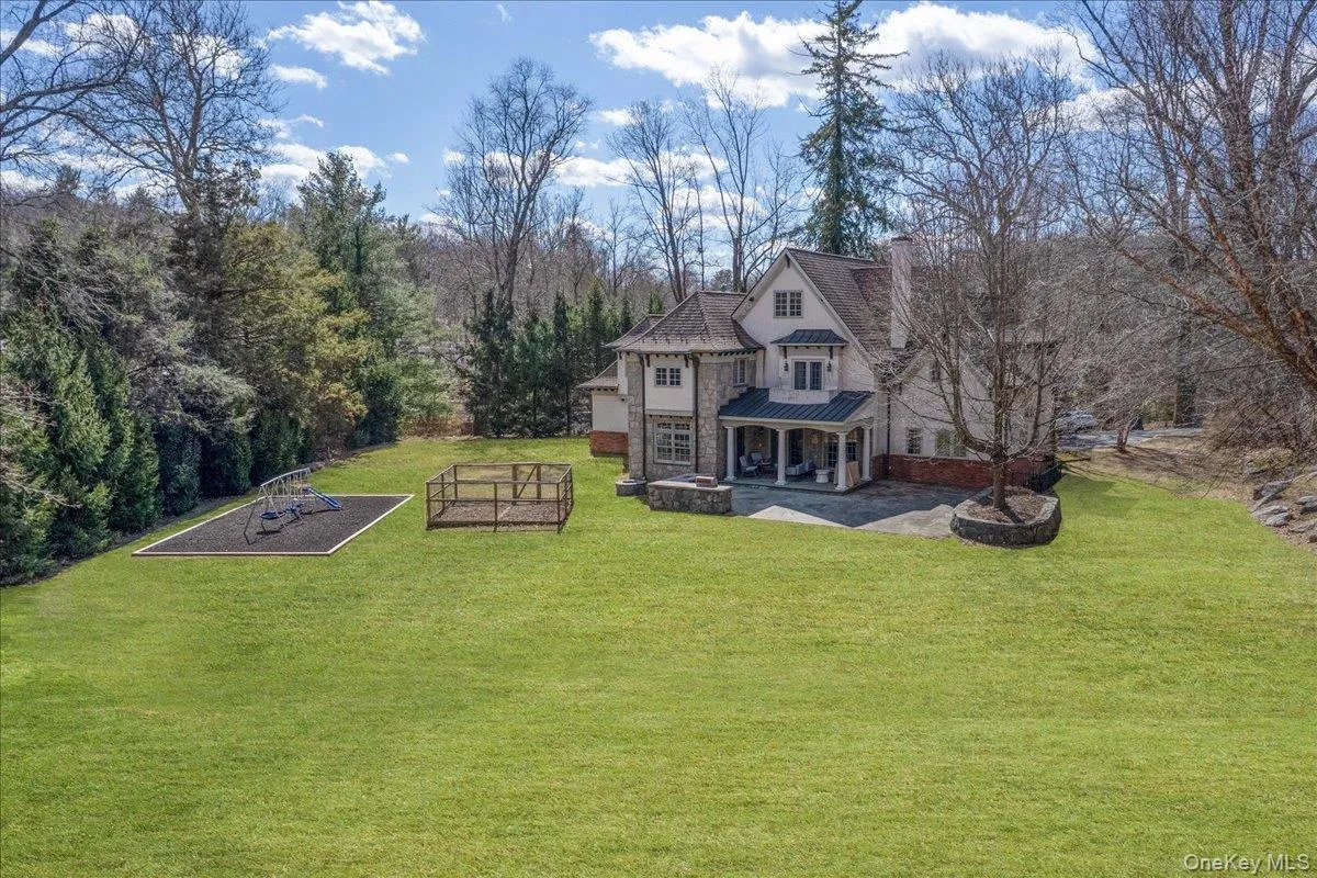 Sprawling, flat backyard framed by mature trees, offering an ideal setting for outdoor play and relaxation Sprawling, flat backyard framed by mature trees, offering an ideal setting for outdoor play and relaxation
