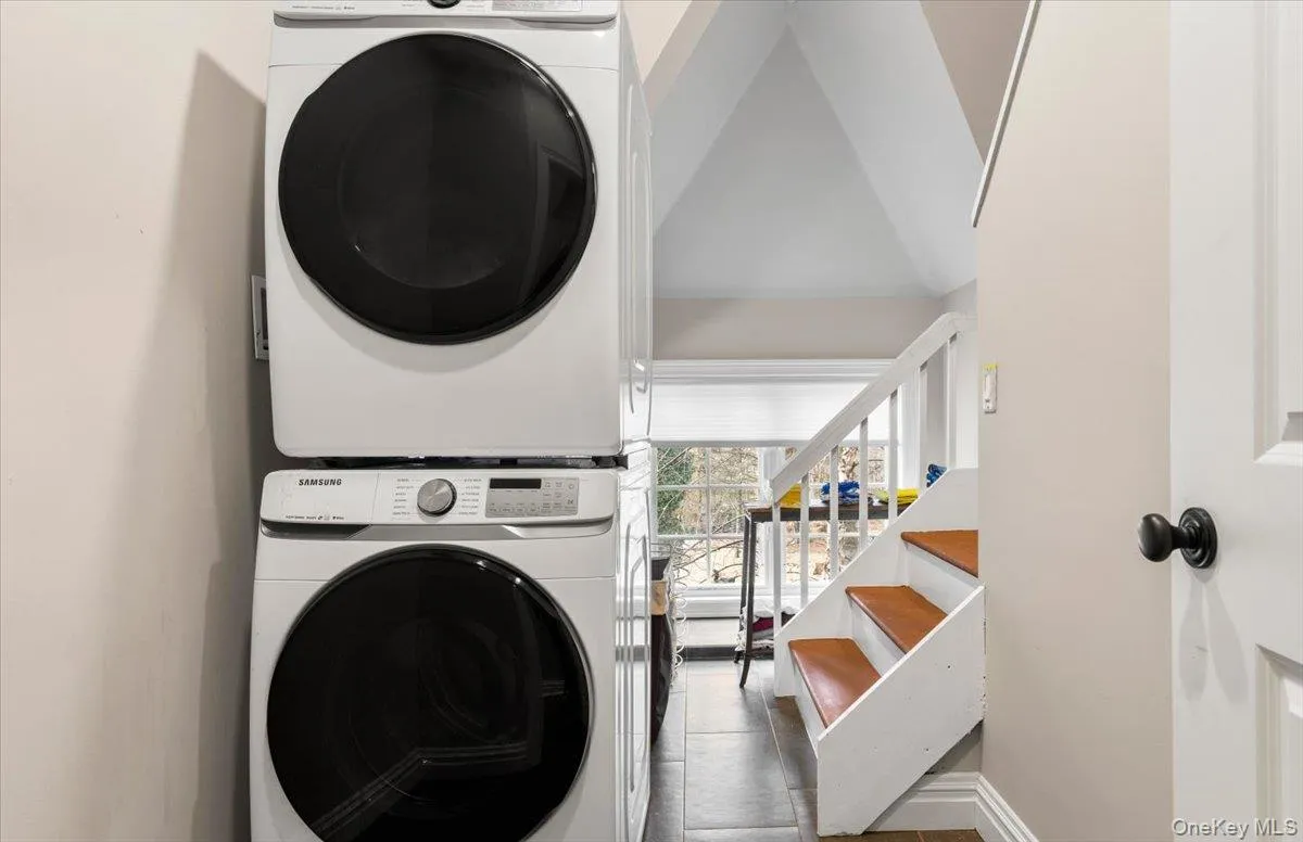 Dedicated second-floor laundry area featuring a modern stackable washer and dryer set Dedicated second-floor laundry area featuring a modern stackable washer and dryer set