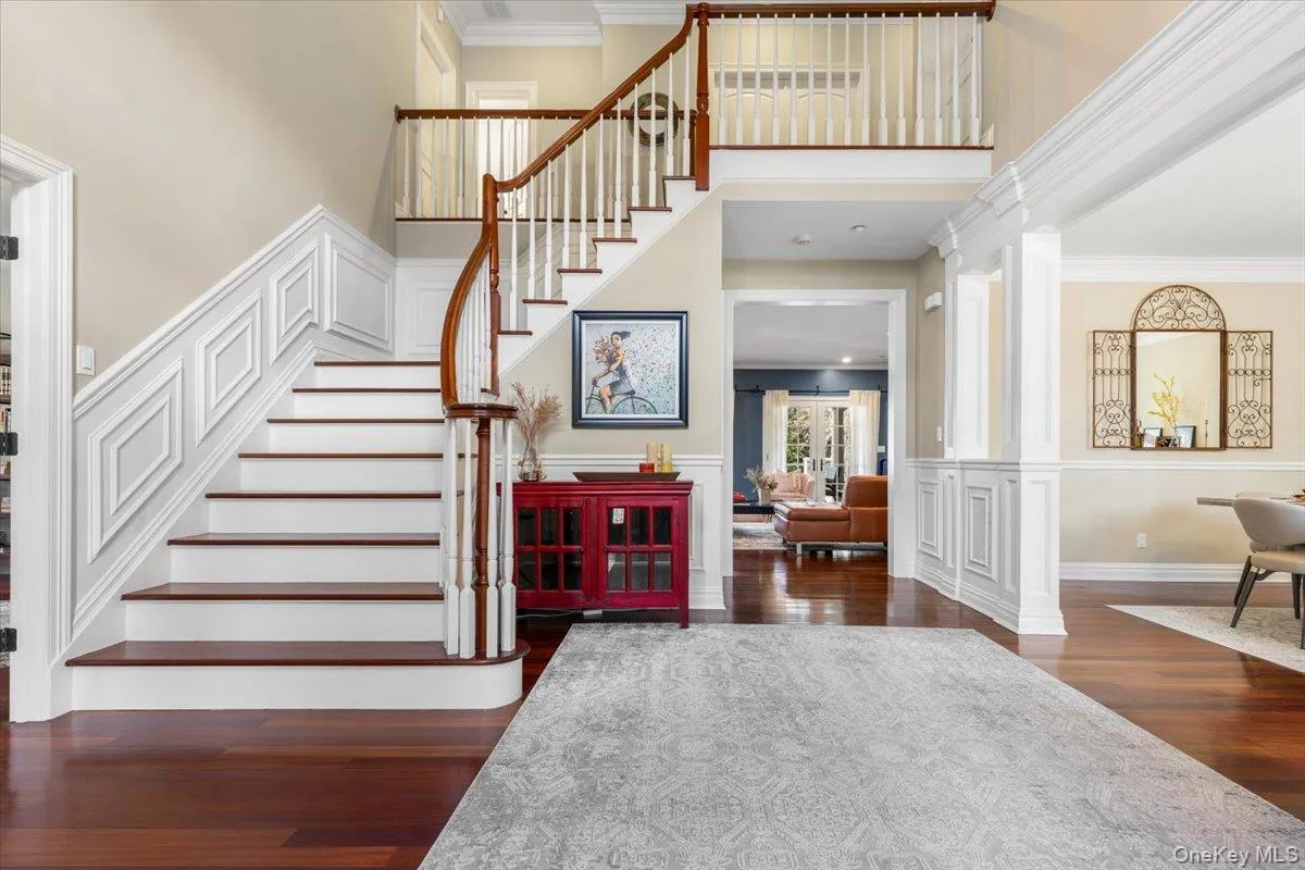 A dramatic, light-filled grand foyer entrance showcasing high ceilings, ornamental molding, and beautiful wood floors. A dramatic, light-filled grand foyer entrance showcasing high ceilings, ornamental molding, and beautiful wood floors.