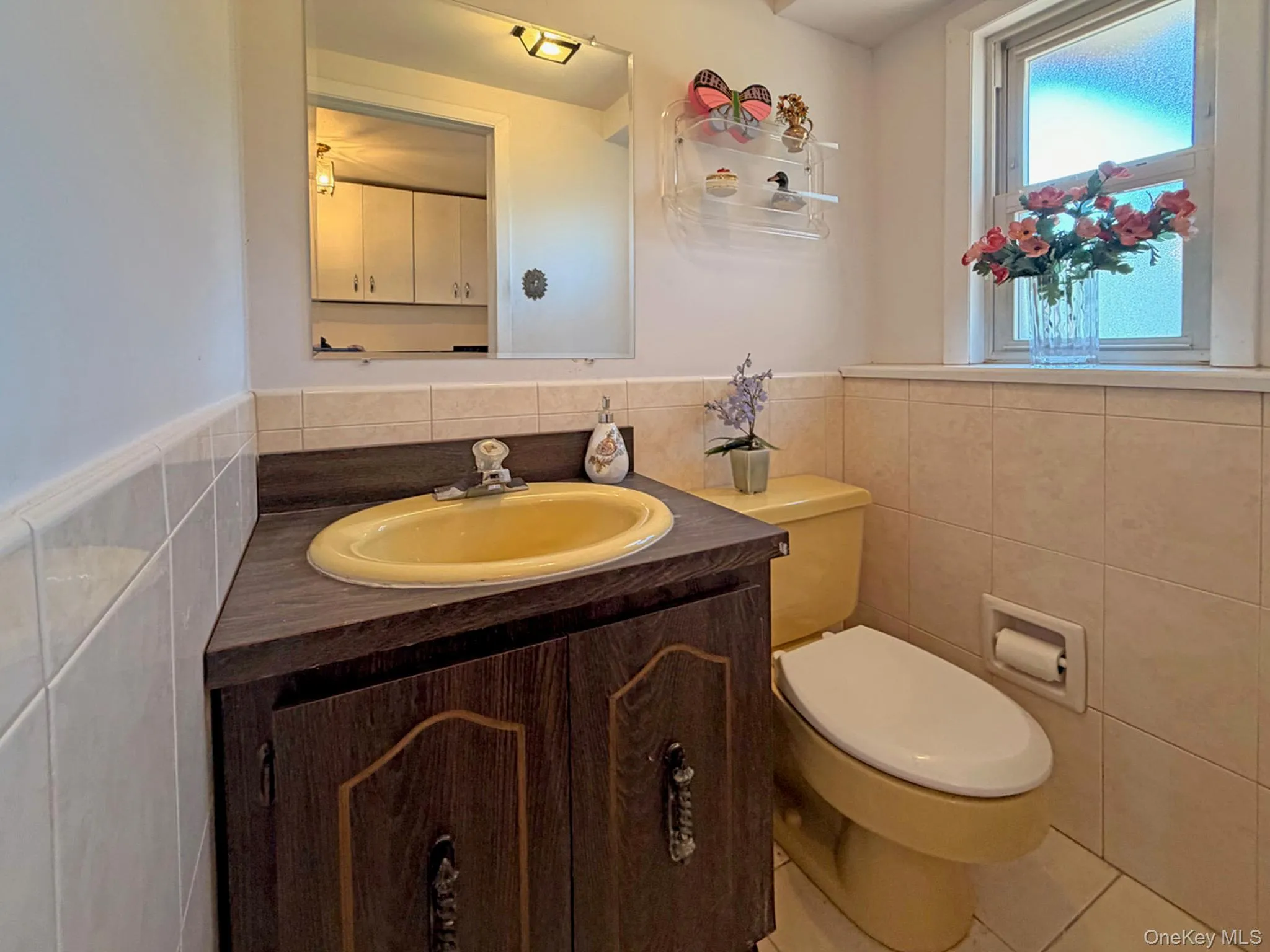 Corner vanity with a yellow oval basin, wood-finish cabinetry, and a mirrored medicine cabinet Corner vanity with a yellow oval basin, wood-finish cabinetry, and a mirrored medicine cabinet