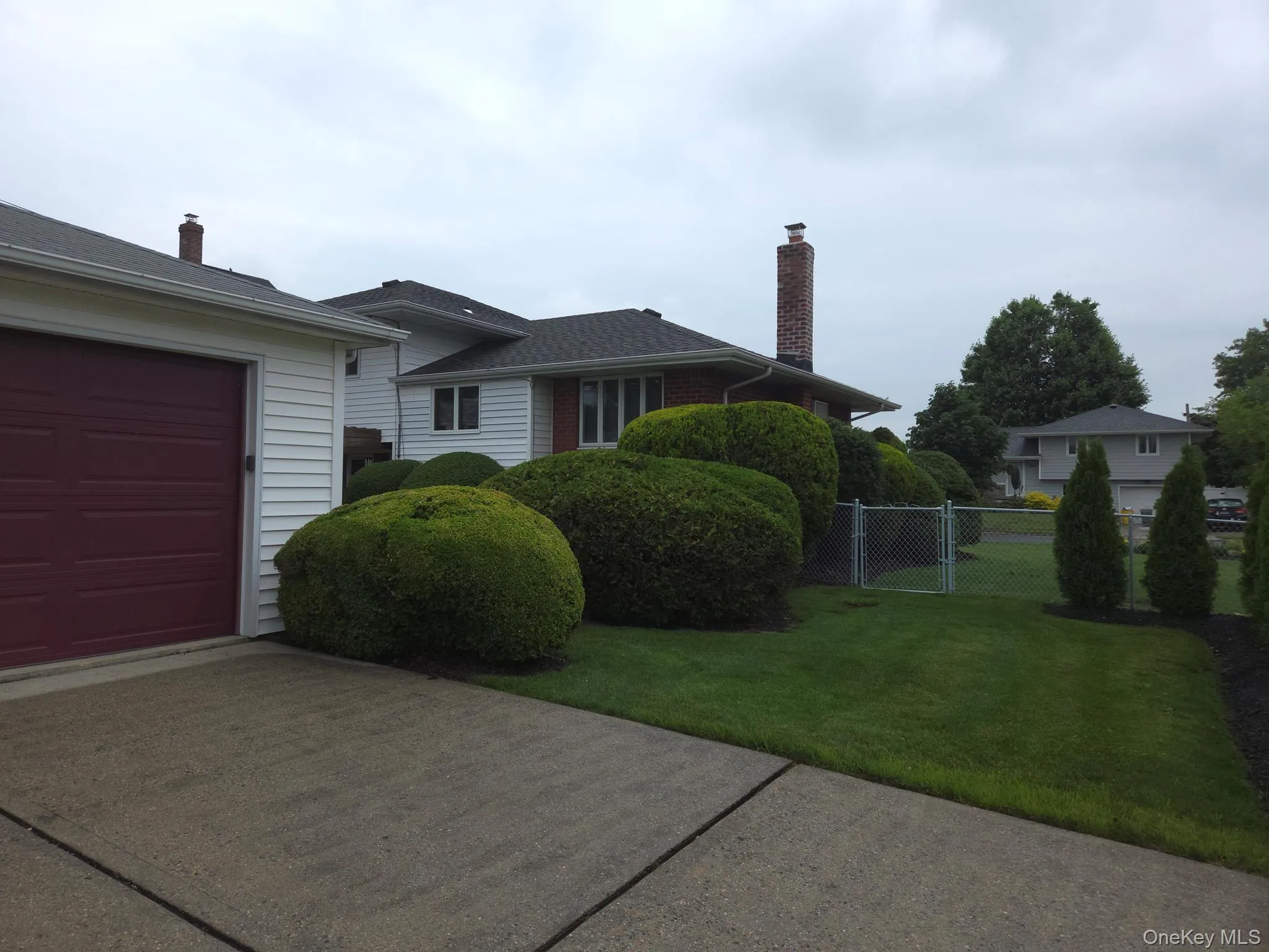 Detached 2 car garage featuring white horizontal siding, a dark red garage door, and a coordinating dark red side door Detached 2 car garage featuring white horizontal siding, a dark red garage door, and a coordinating dark red side door