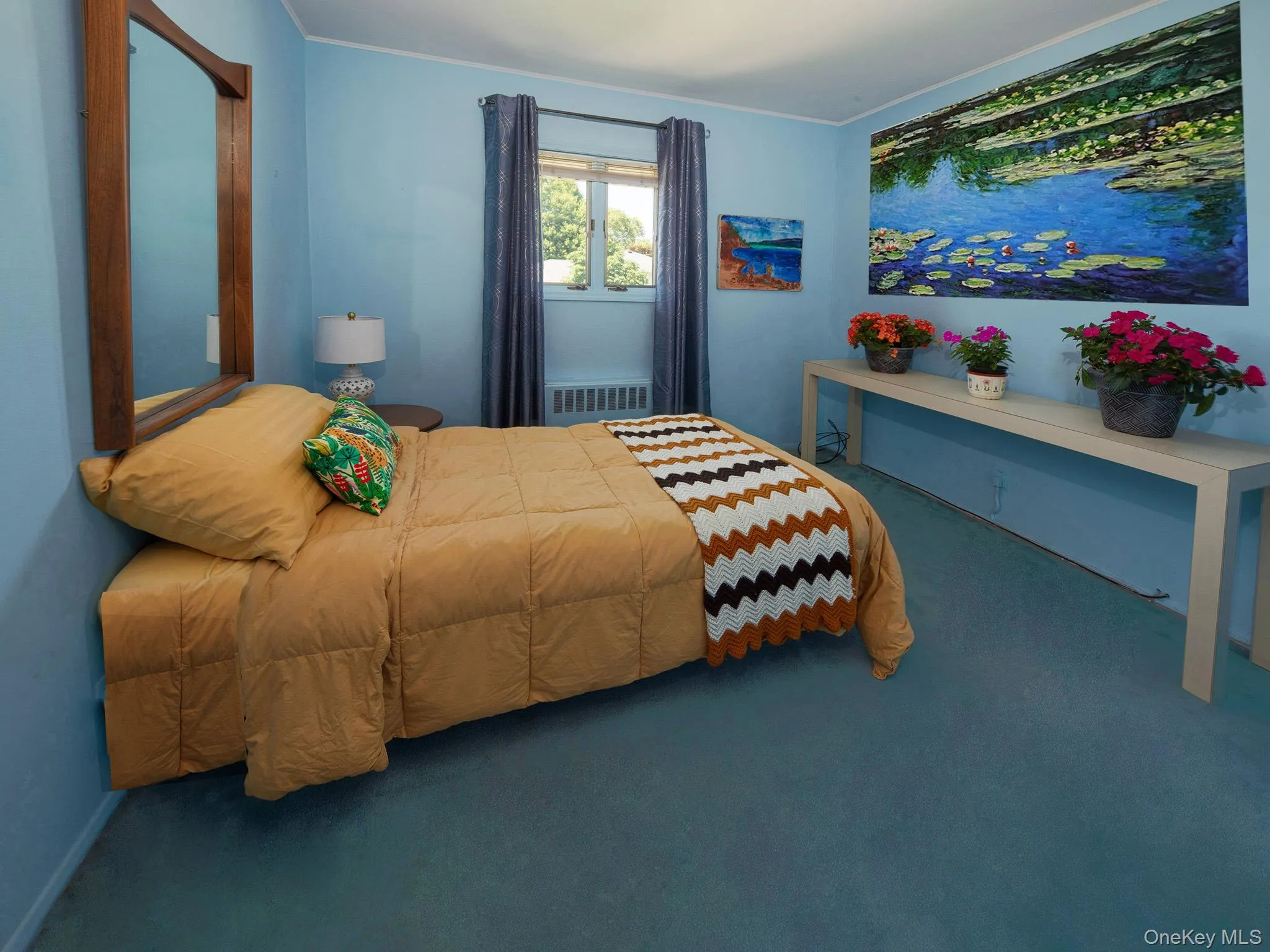 Carpeted interior space featuring a window with drapes, a wall-mounted mirror with a wood frame, and a built-in radiator Carpeted interior space featuring a window with drapes, a wall-mounted mirror with a wood frame, and a built-in radiator
