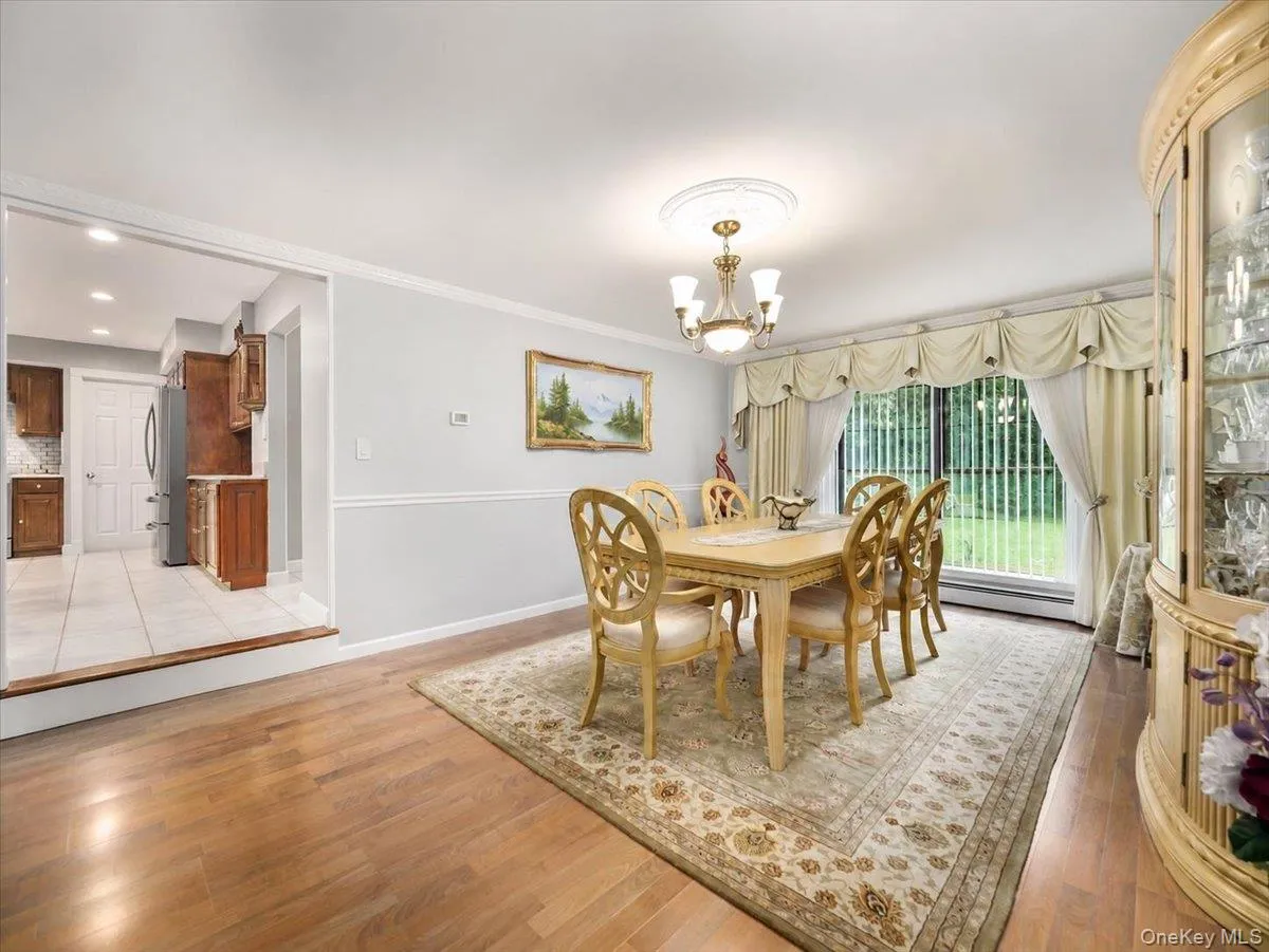 Formal dining area featuring hardwood flooring, crown molding, and a decorative chandelier with a ceiling medallion Formal dining area featuring hardwood flooring, crown molding, and a decorative chandelier with a ceiling medallion