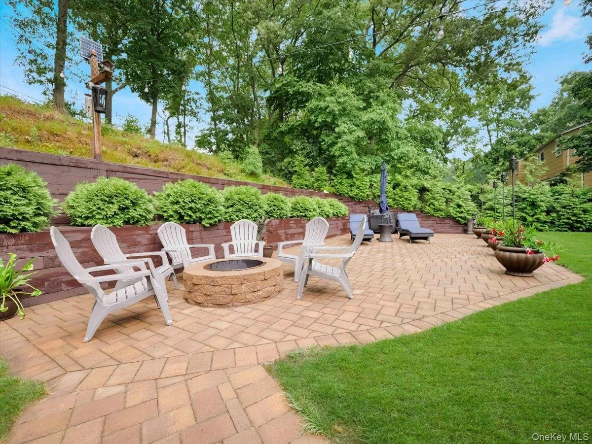 Expansive paver patio featuring a built-in stone fire pit Expansive paver patio featuring a built-in stone fire pit