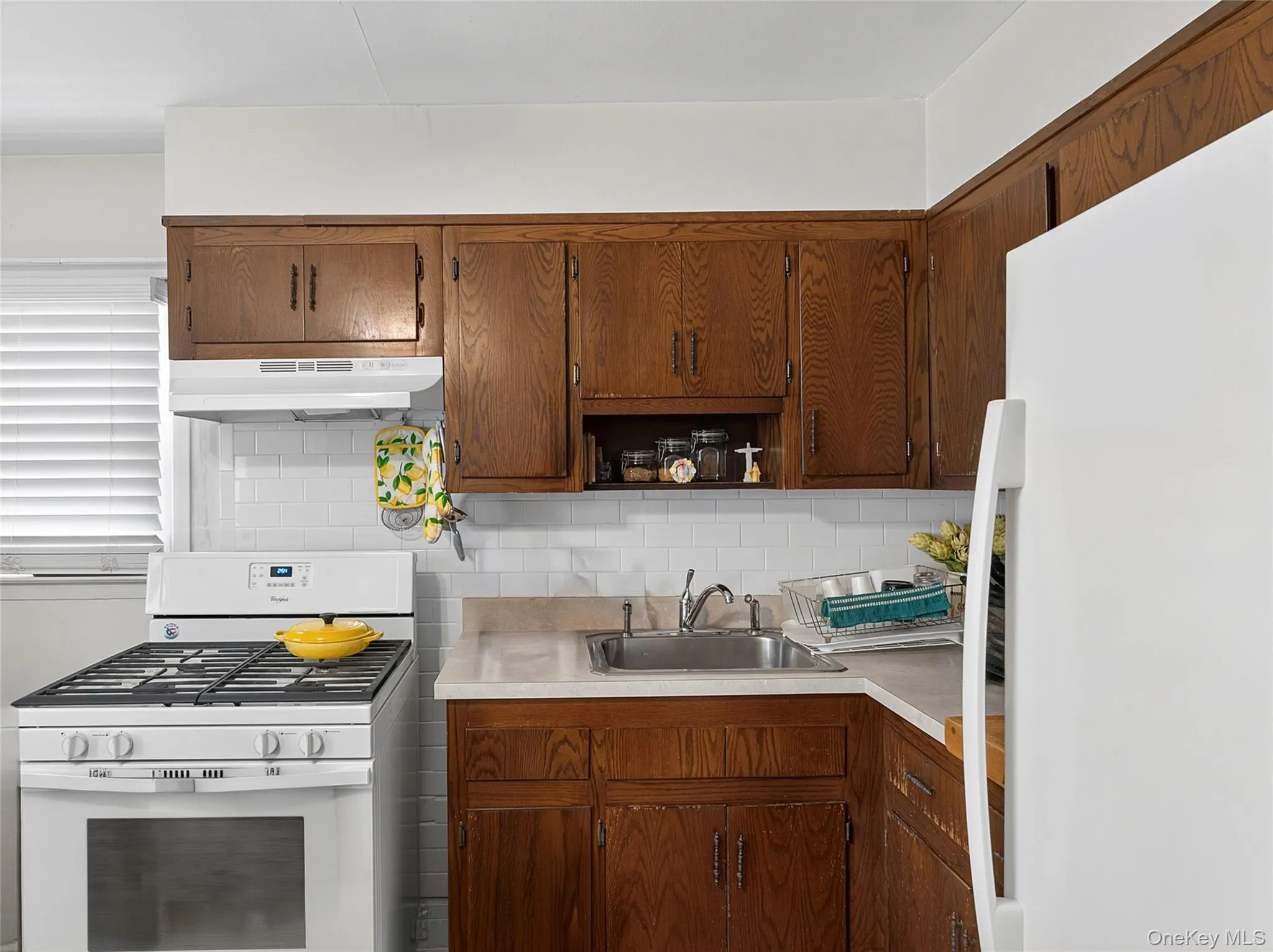 Kitchen with wood-finish cabinetry and white appliances Kitchen with wood-finish cabinetry and white appliances