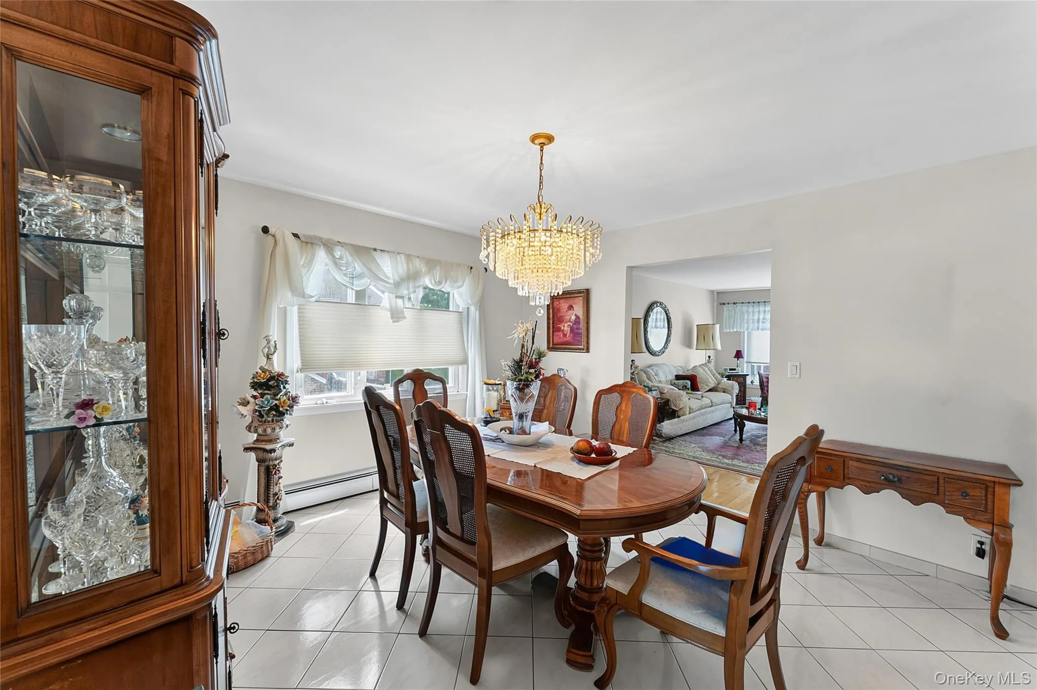 Dining area featuring a prominent crystal chandelier and tile flooring Dining area featuring a prominent crystal chandelier and tile flooring