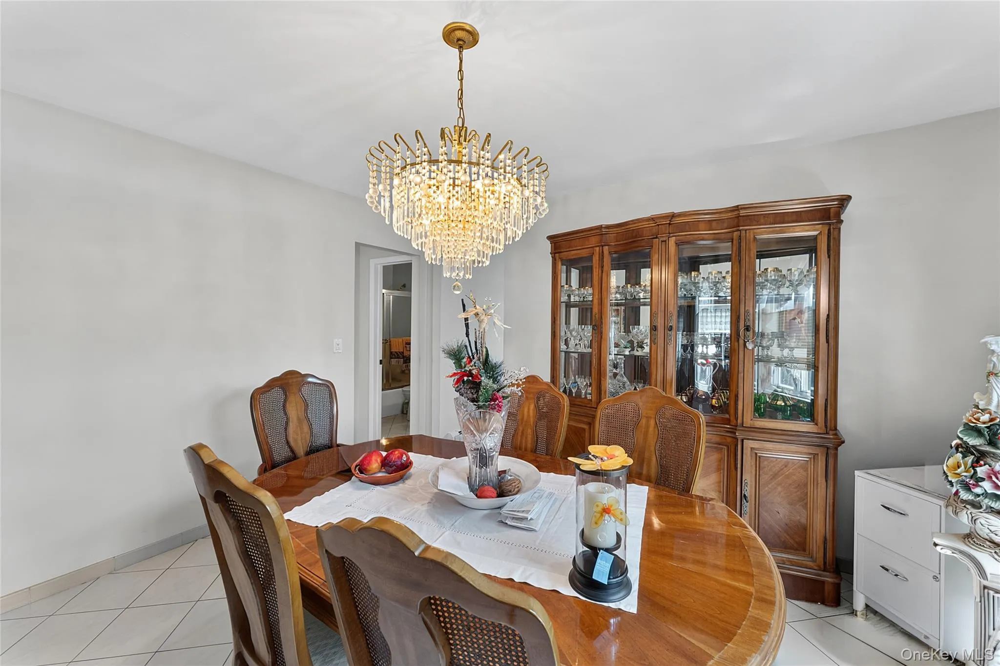 Dining area with a polished wood-finish table, a decorative chandelier, and light-toned walls Dining area with a polished wood-finish table, a decorative chandelier, and light-toned walls