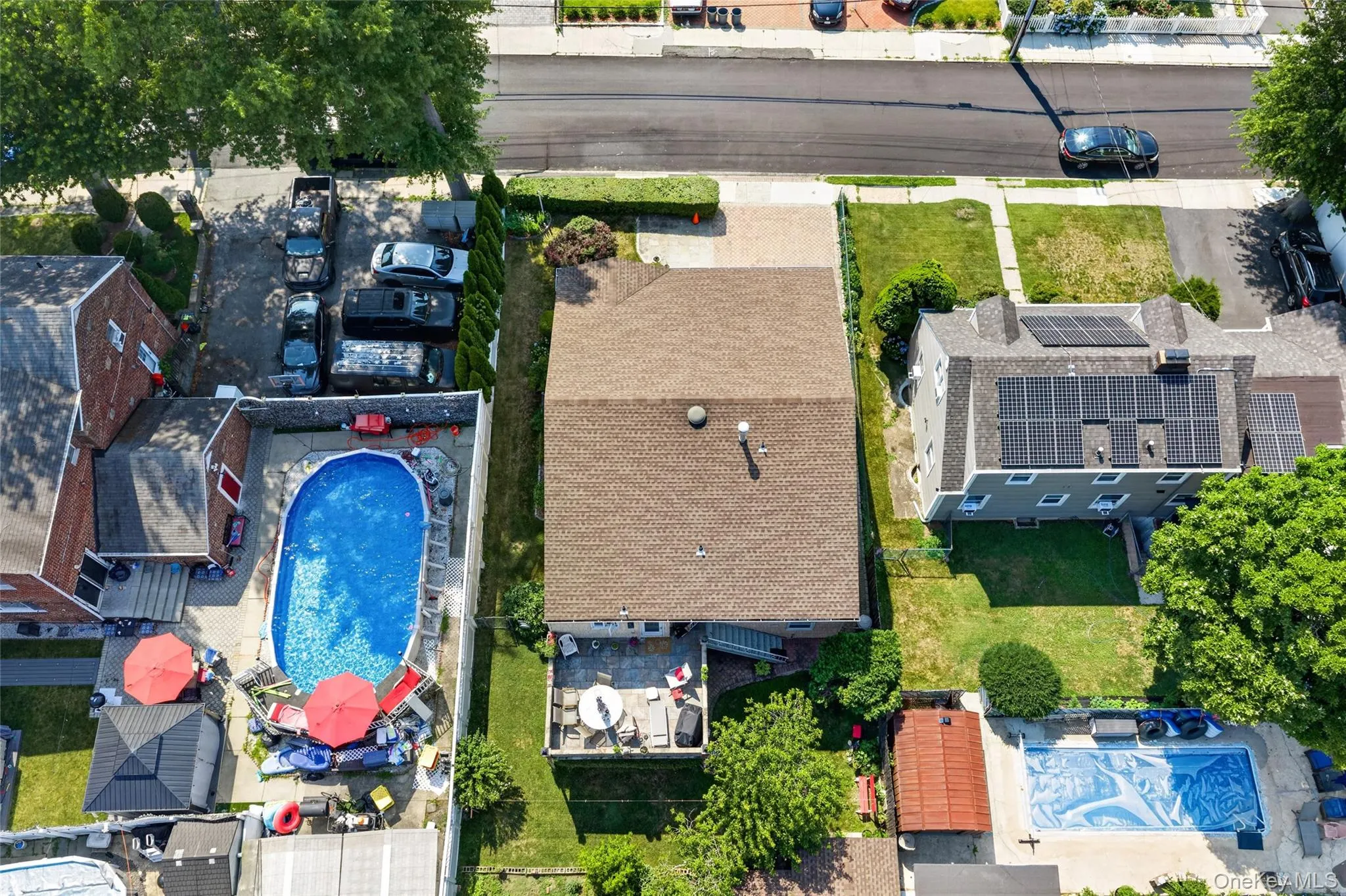 Expansive residential property featuring a large backyard patio, a well-maintained lawn, and mature trees Expansive residential property featuring a large backyard patio, a well-maintained lawn, and mature trees