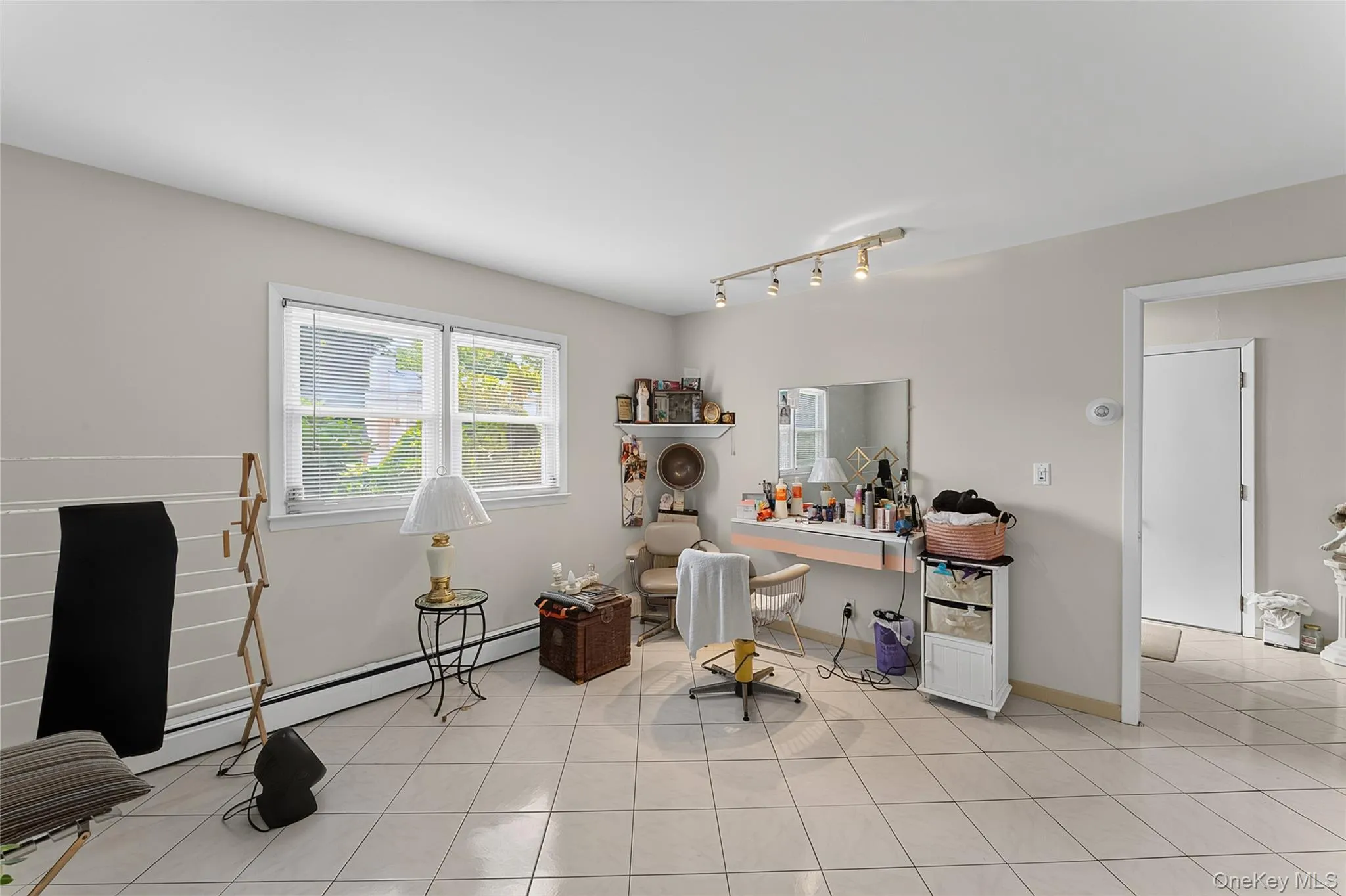 Spacious interior with neutral wall tones and light-toned square tile flooring Spacious interior with neutral wall tones and light-toned square tile flooring