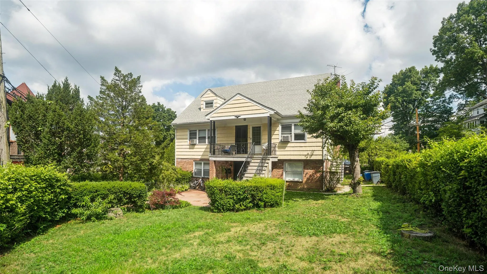 Rear exterior featuring two levels of outdoor living, a brick patio, and a staircase Rear exterior featuring two levels of outdoor living, a brick patio, and a staircase