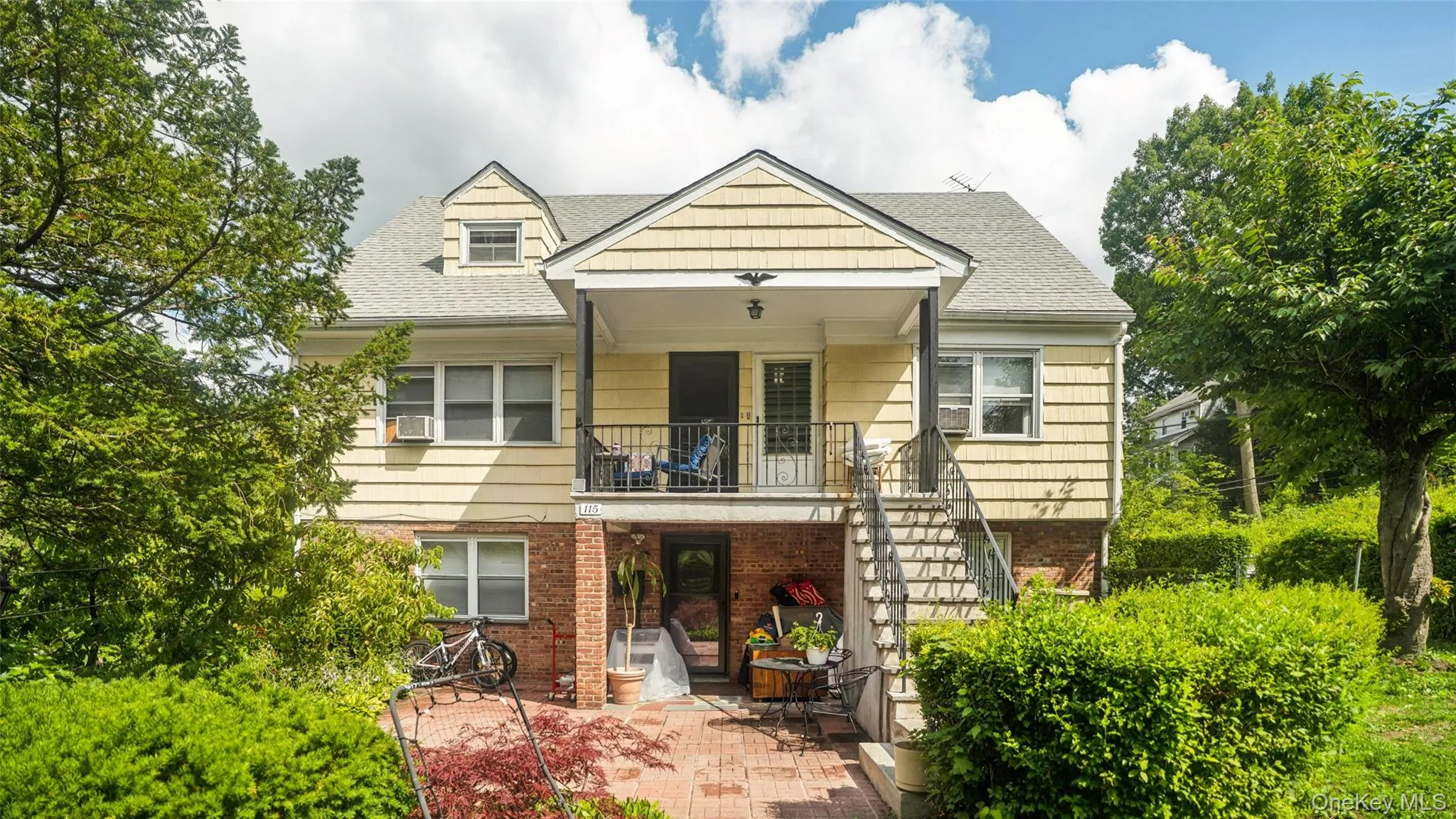 Rear exterior featuring two levels of outdoor living, a brick patio, and a staircase Rear exterior featuring two levels of outdoor living, a brick patio, and a staircase