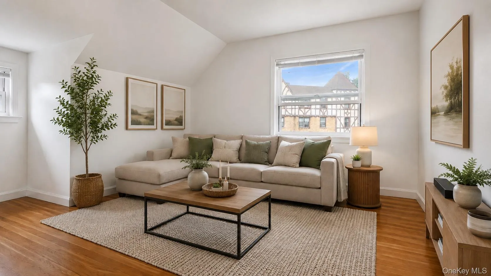 Living area featuring wood-finish flooring, white walls, and a prominent window Living area featuring wood-finish flooring, white walls, and a prominent window