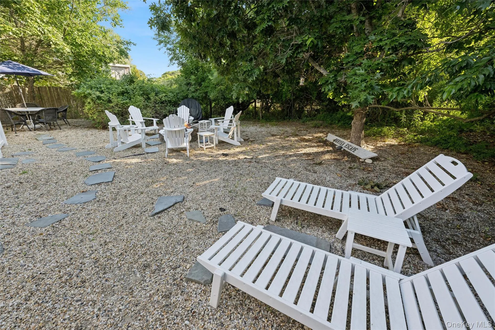 Expansive outdoor area featuring gravel ground cover, stepping stones, and mature trees providing natural shade Expansive outdoor area featuring gravel ground cover, stepping stones, and mature trees providing natural shade
