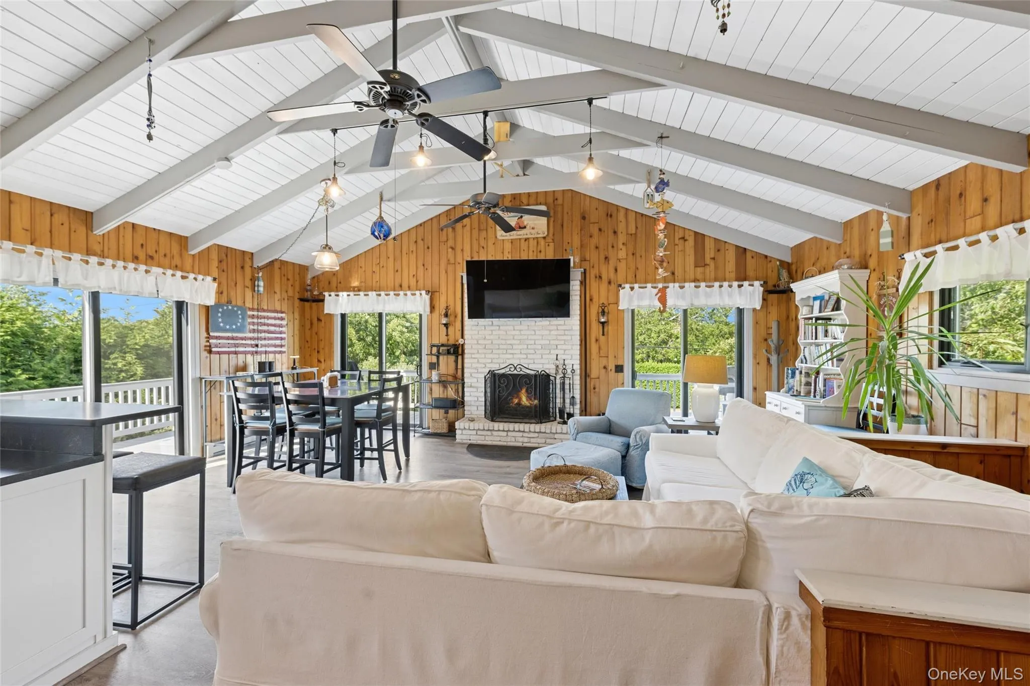 Vaulted ceiling featuring exposed beams and wood-paneled walls Vaulted ceiling featuring exposed beams and wood-paneled walls