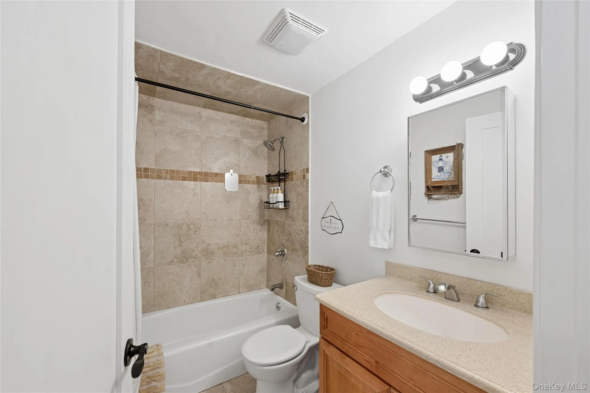Bathroom featuring a vanity with a light-toned countertop, a rectangular undermount sink, and a chrome faucet Bathroom featuring a vanity with a light-toned countertop, a rectangular undermount sink, and a chrome faucet