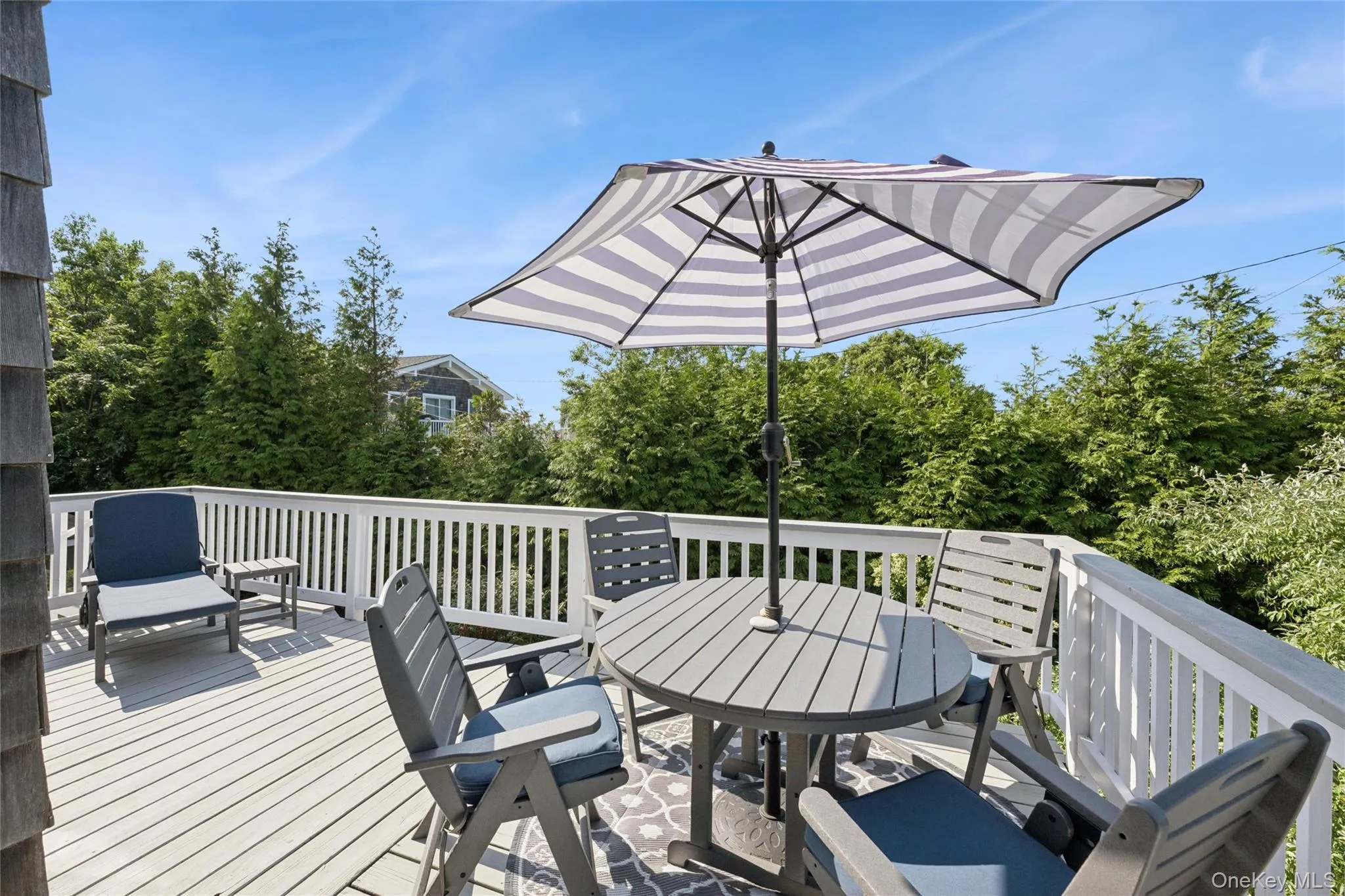 Spacious outdoor deck featuring light-toned decking and a white railing system Spacious outdoor deck featuring light-toned decking and a white railing system
