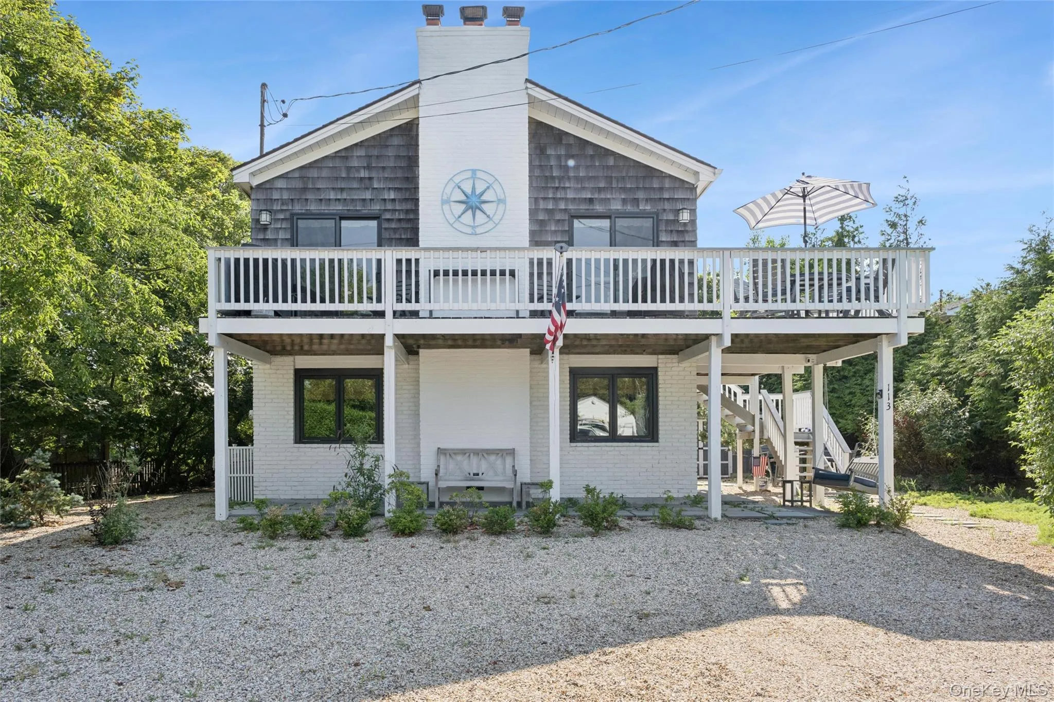 Two-story residence featuring a shingled upper level and white brick lower level Two-story residence featuring a shingled upper level and white brick lower level