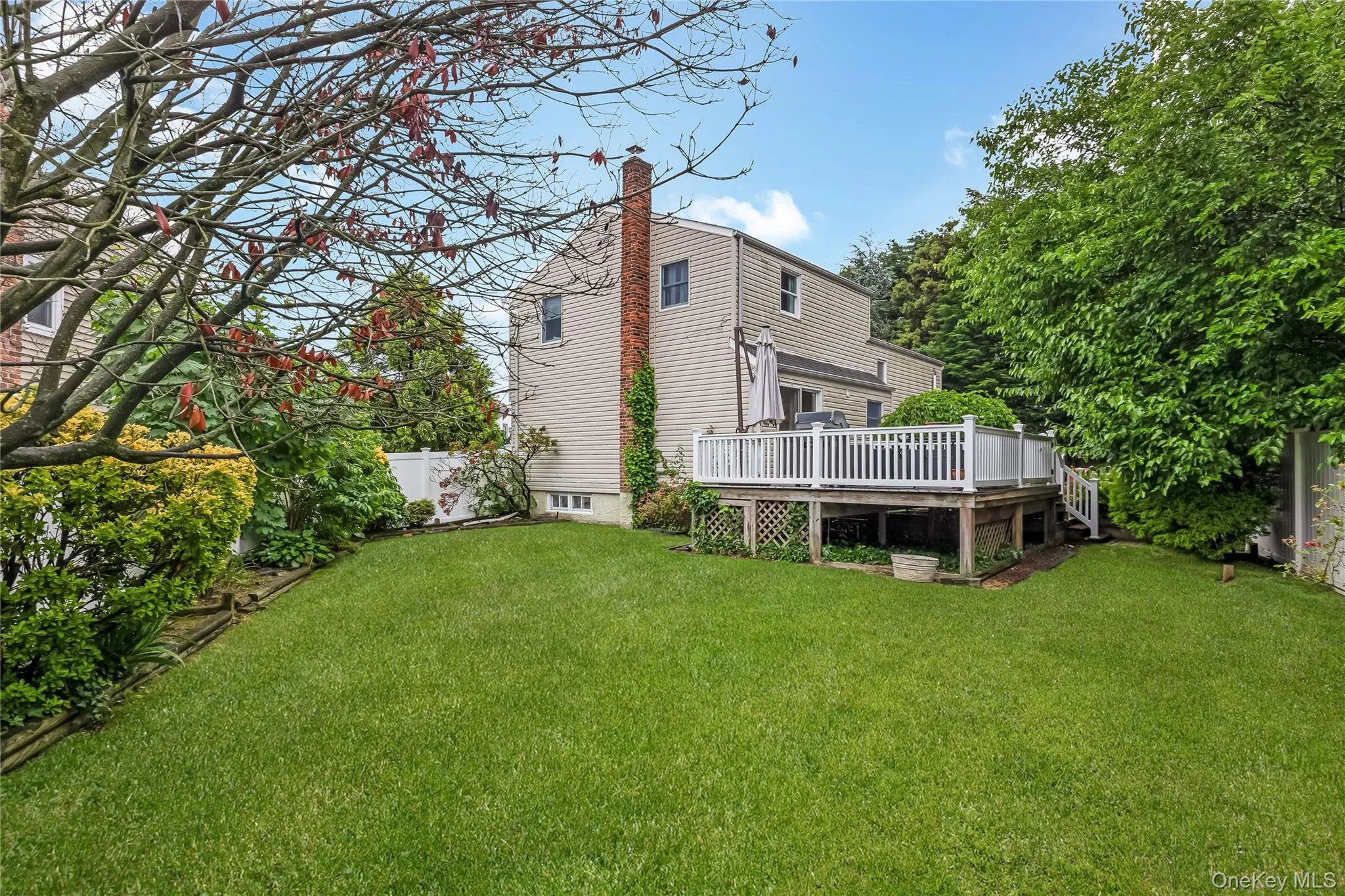 Side Yard featuring mature trees, and a white privacy fence Side Yard featuring mature trees, and a white privacy fence