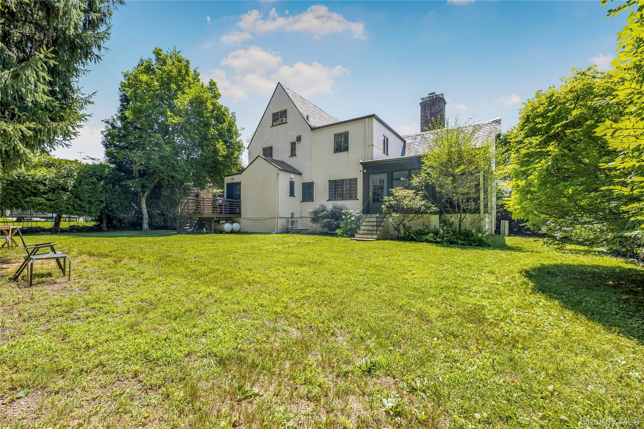 Expansive backyard featuring mature landscaping, a screened patio, rear deck, and exceptional space for entertaining and outdoor enjoyment. Expansive backyard featuring mature landscaping, a screened patio, rear deck, and exceptional space for entertaining and outdoor enjoyment.