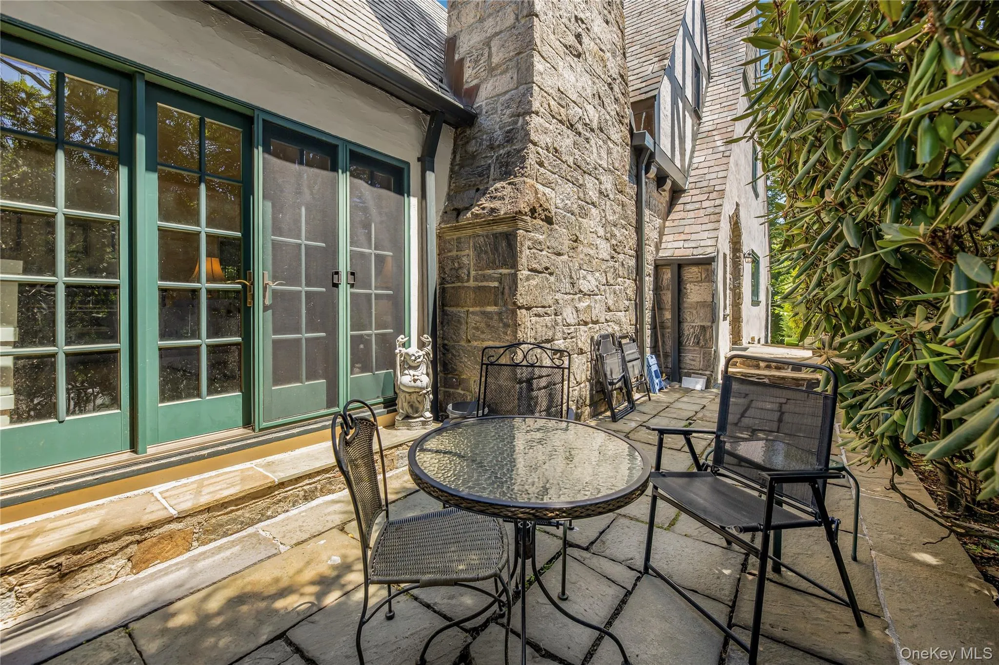 Stone patio just outside the screened porch, offering an inviting setting for outdoor dining and entertaining. Stone patio just outside the screened porch, offering an inviting setting for outdoor dining and entertaining.