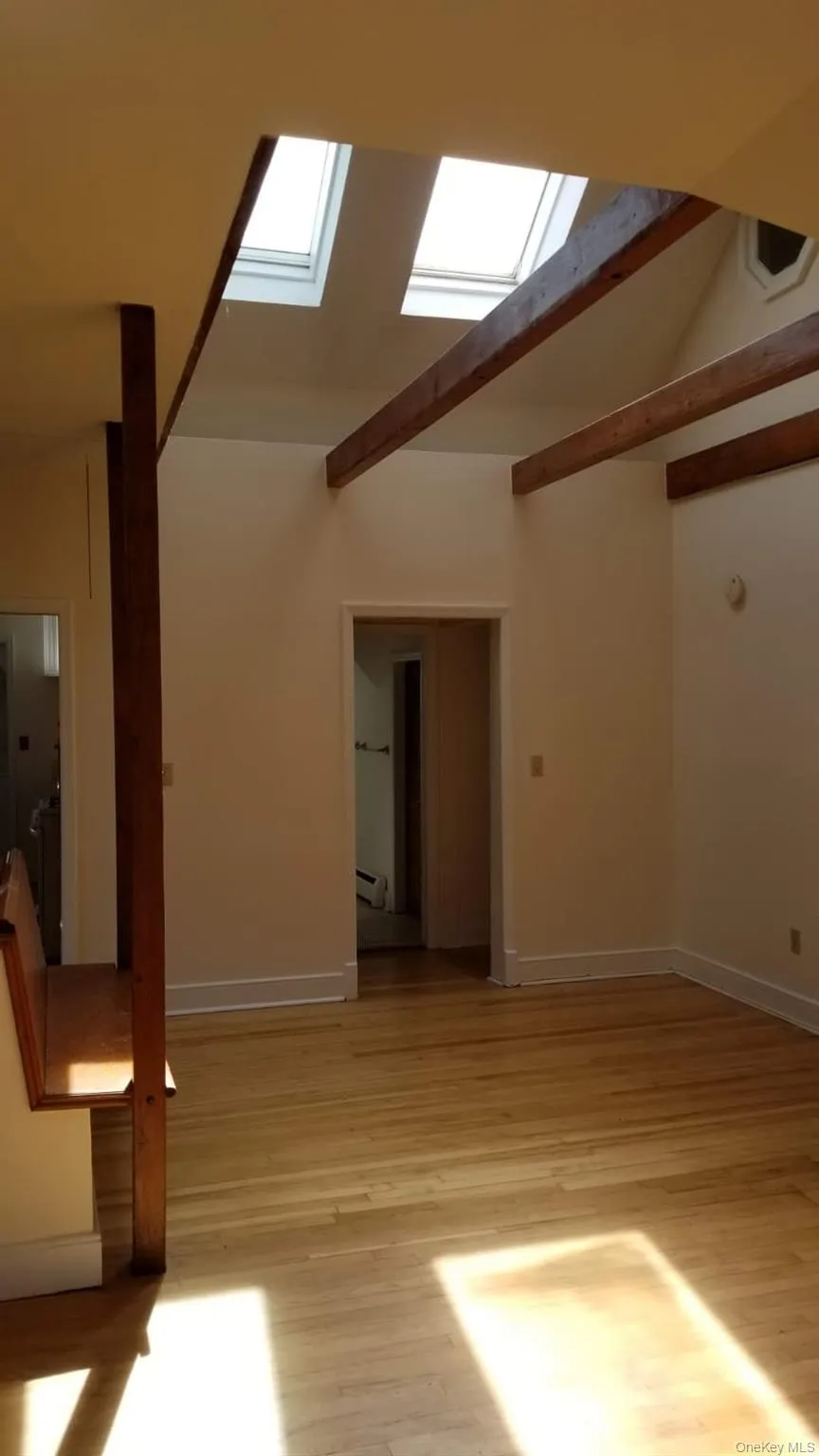 Vaulted ceiling featuring skylights and exposed wood beams Vaulted ceiling featuring skylights and exposed wood beams