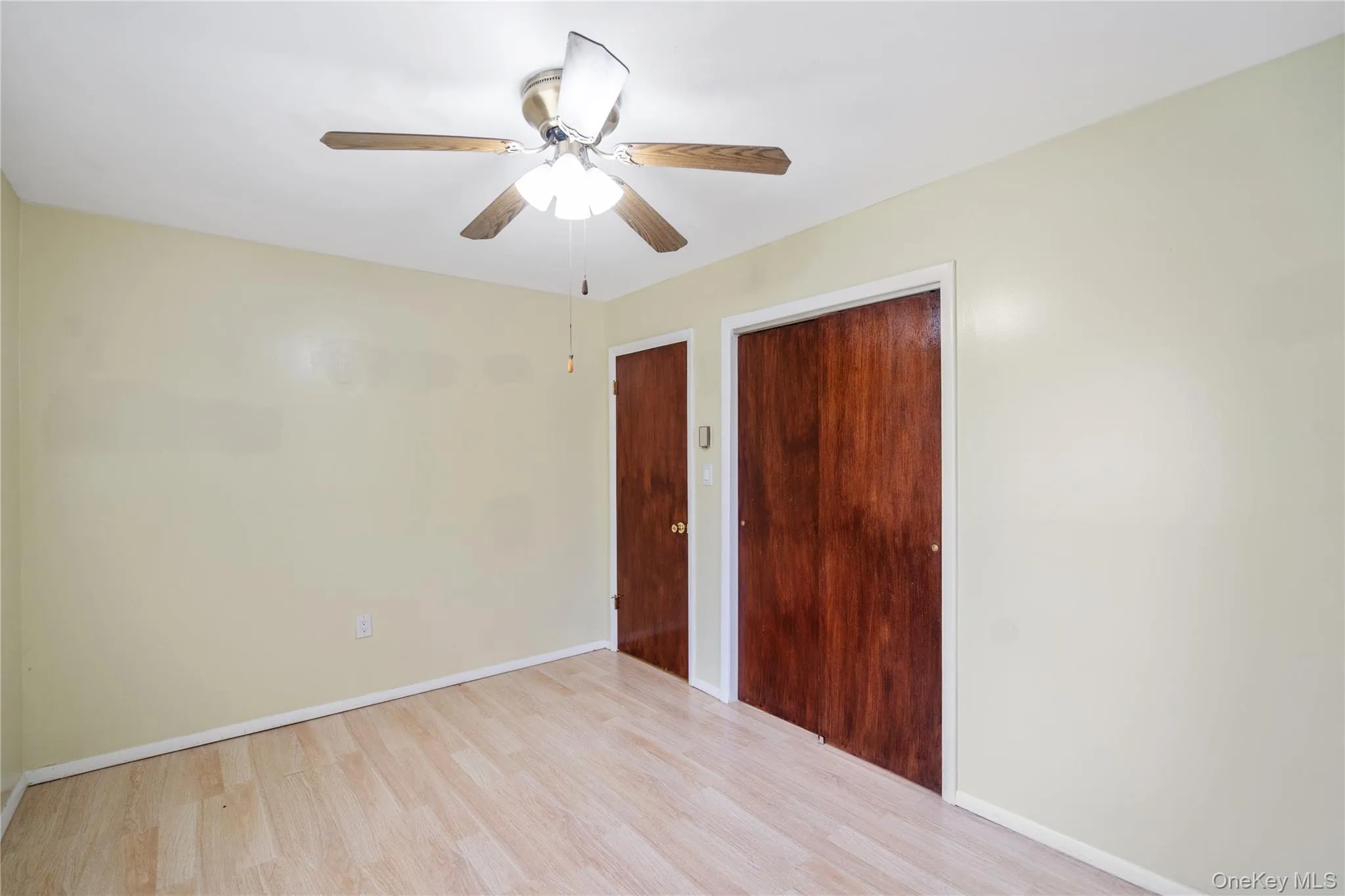 Spare room featuring wood finished floors, baseboards, and a ceiling fan Spare room featuring wood finished floors, baseboards, and a ceiling fan