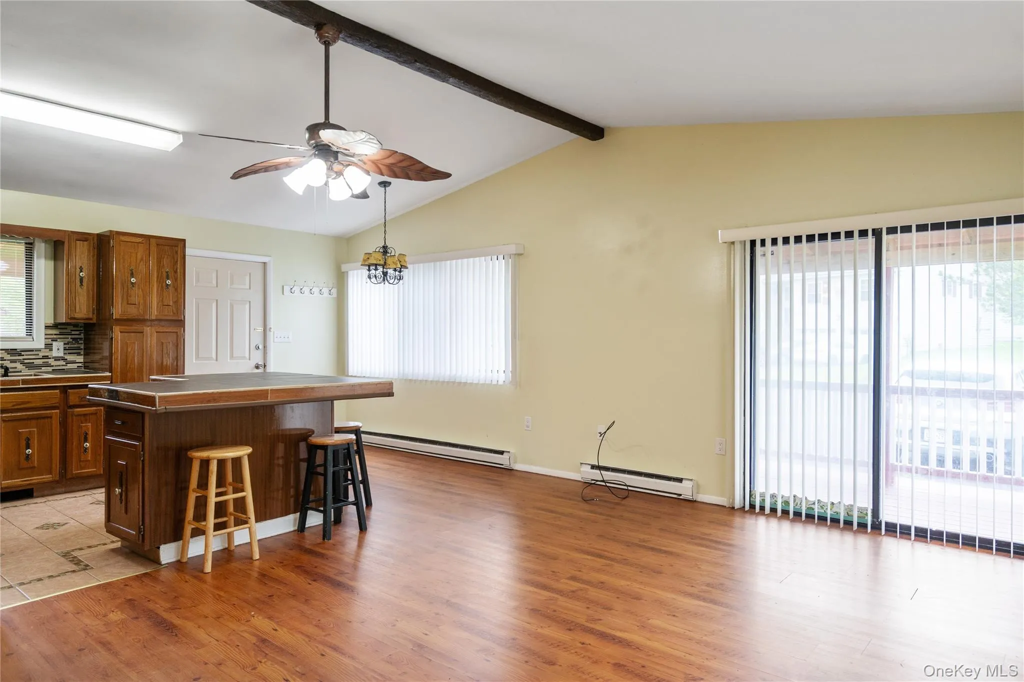 Kitchen featuring a baseboard radiator, a breakfast bar, and healthy amount of natural light Kitchen featuring a baseboard radiator, a breakfast bar, and healthy amount of natural light