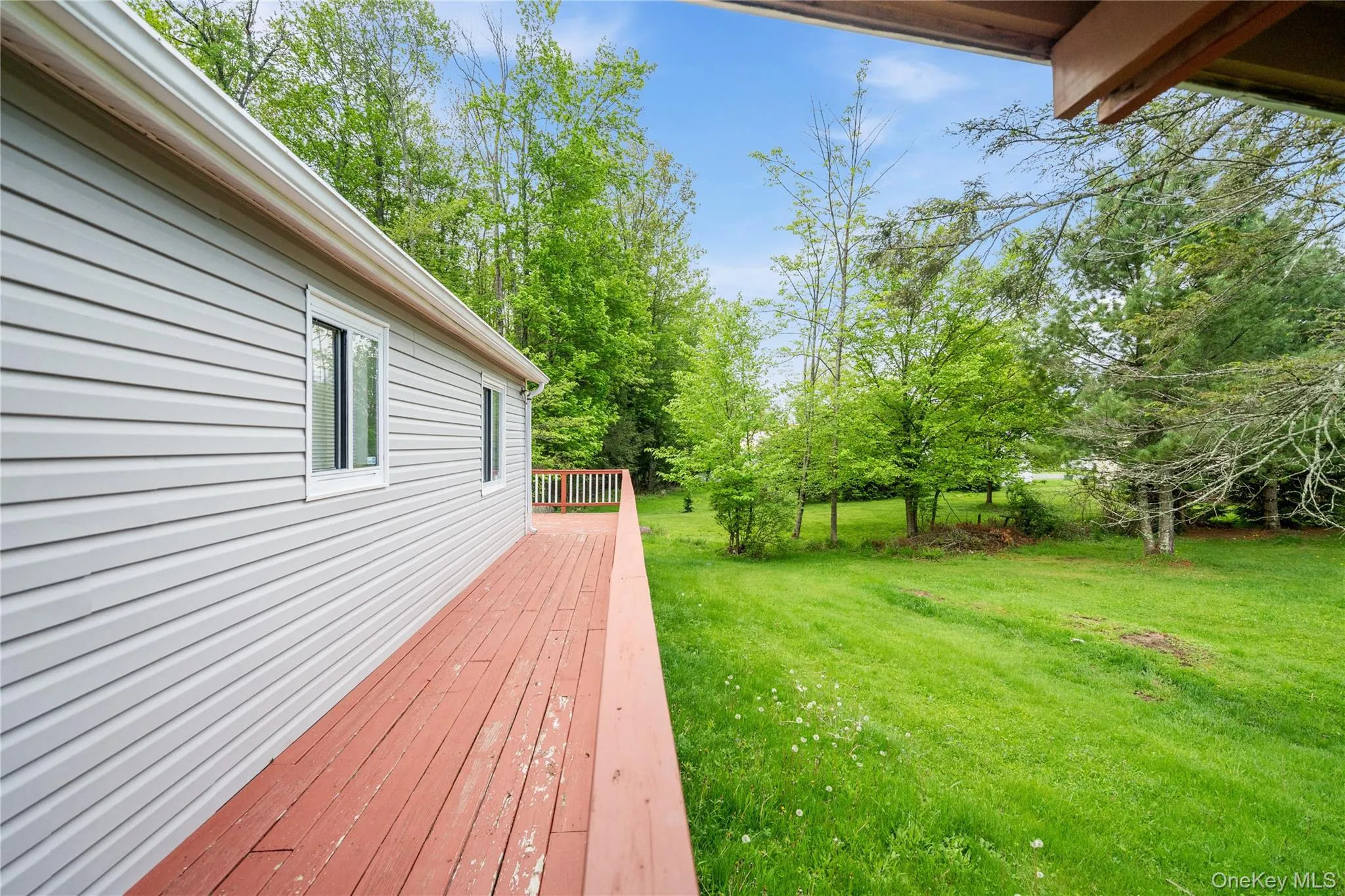 Wooden terrace featuring a lawn Wooden terrace featuring a lawn