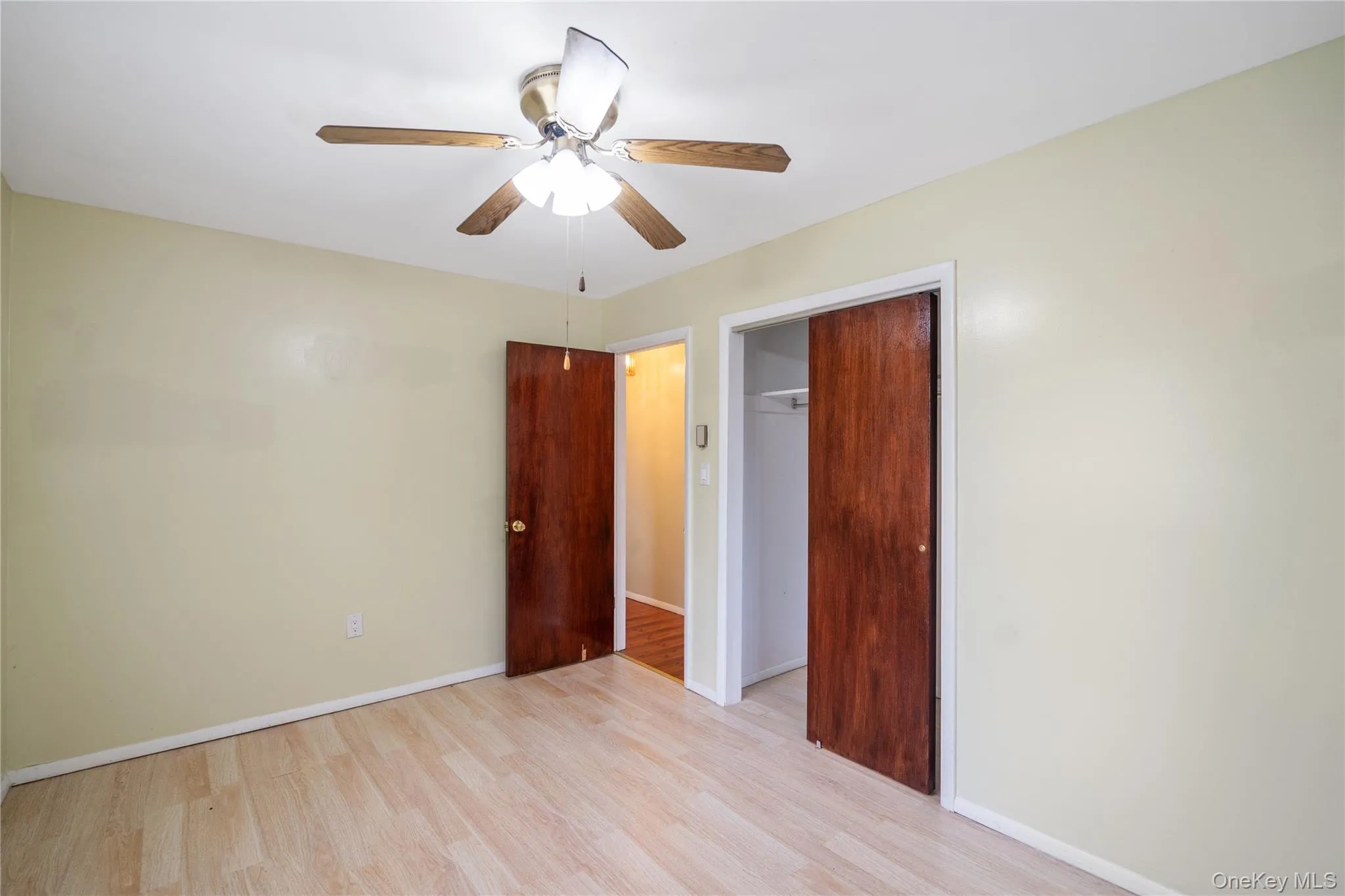 Unfurnished bedroom featuring wood finished floors, a closet, and baseboards Unfurnished bedroom featuring wood finished floors, a closet, and baseboards
